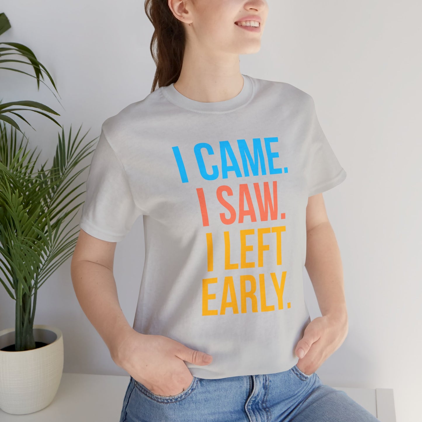 Person wearing a t-shirt with 'I CAME. I SAW. I LEFT EARLY.' text in colorful letters.