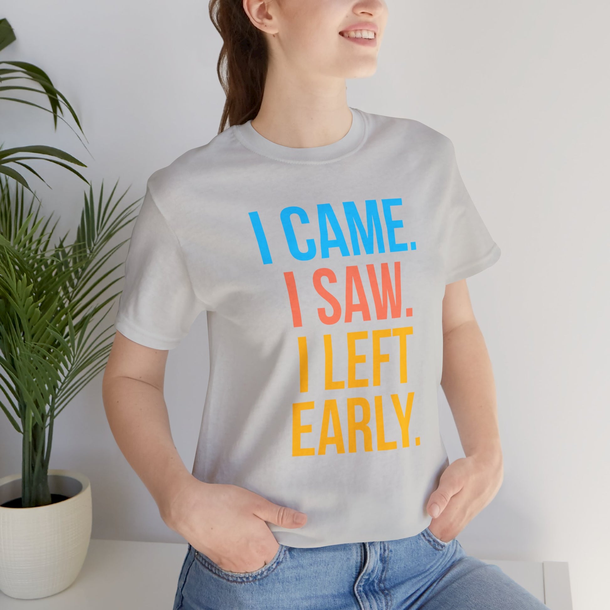Person wearing a t-shirt with 'I CAME. I SAW. I LEFT EARLY.' text in colorful letters.