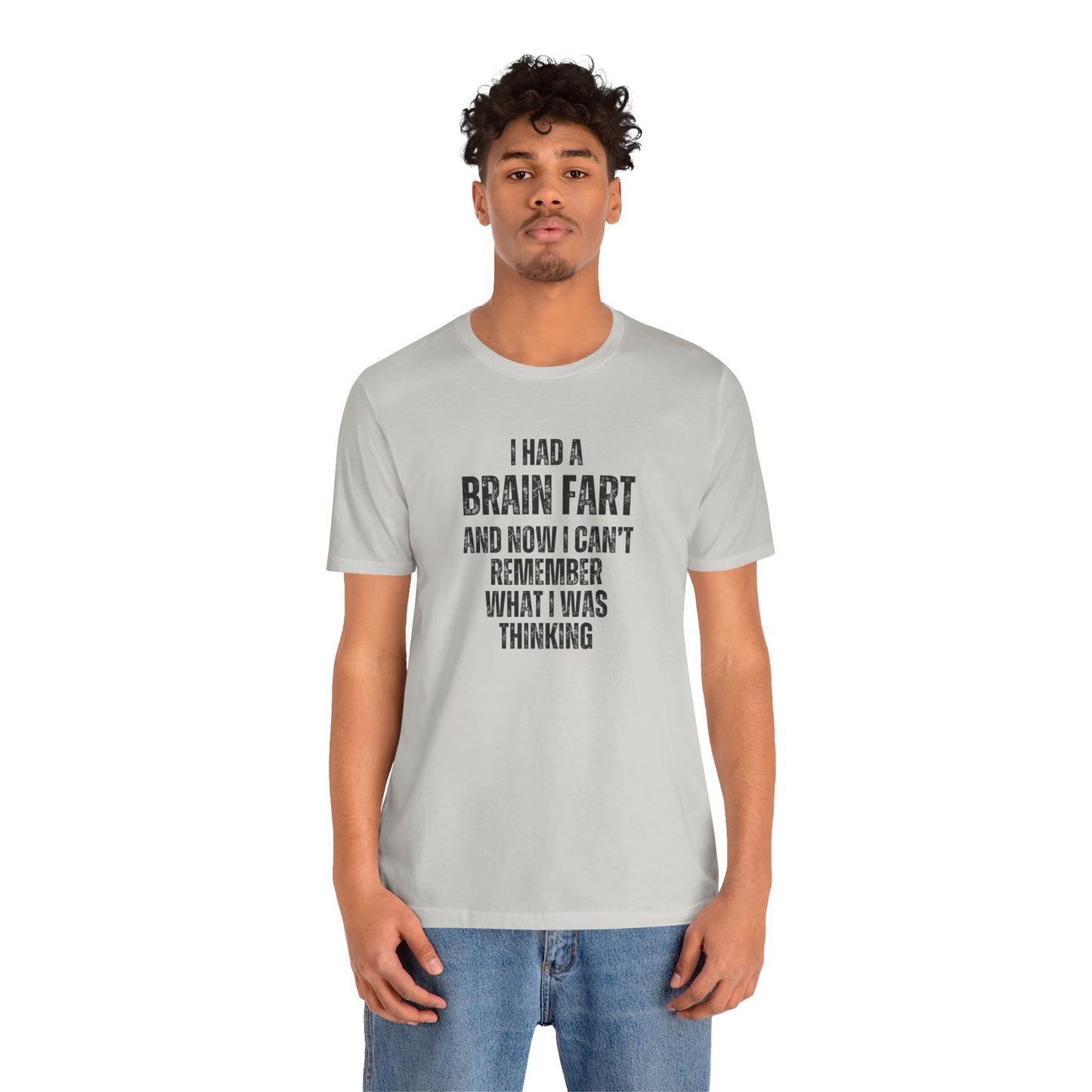 Person wearing a gray t-shirt with humorous text 'I had a brain fart and now I can't remember what I was thinking' design on a white background
