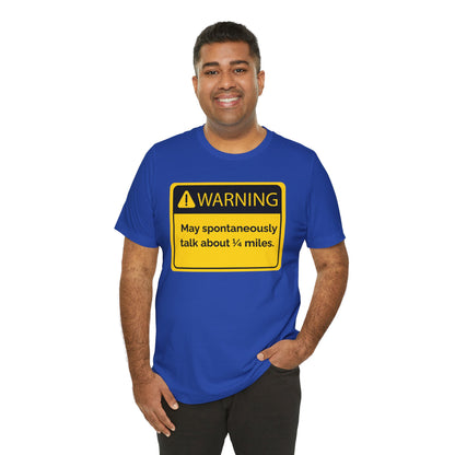 Man wearing a blue t-shirt with a yellow warning sign 'WARNING May spontaneously talk about 1/4 miles' graphic on a white background