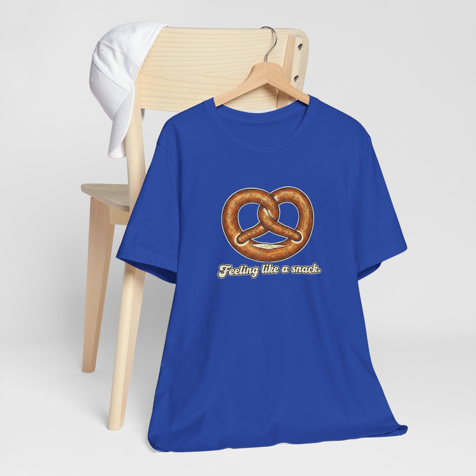 Blue t-shirt with pretzel graphic and text 'Feeling like a snack' on a white background