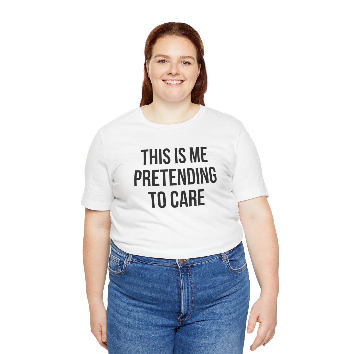 Person wearing a white t-shirt with text 'This is me pretending to care' and blue jeans on a white background