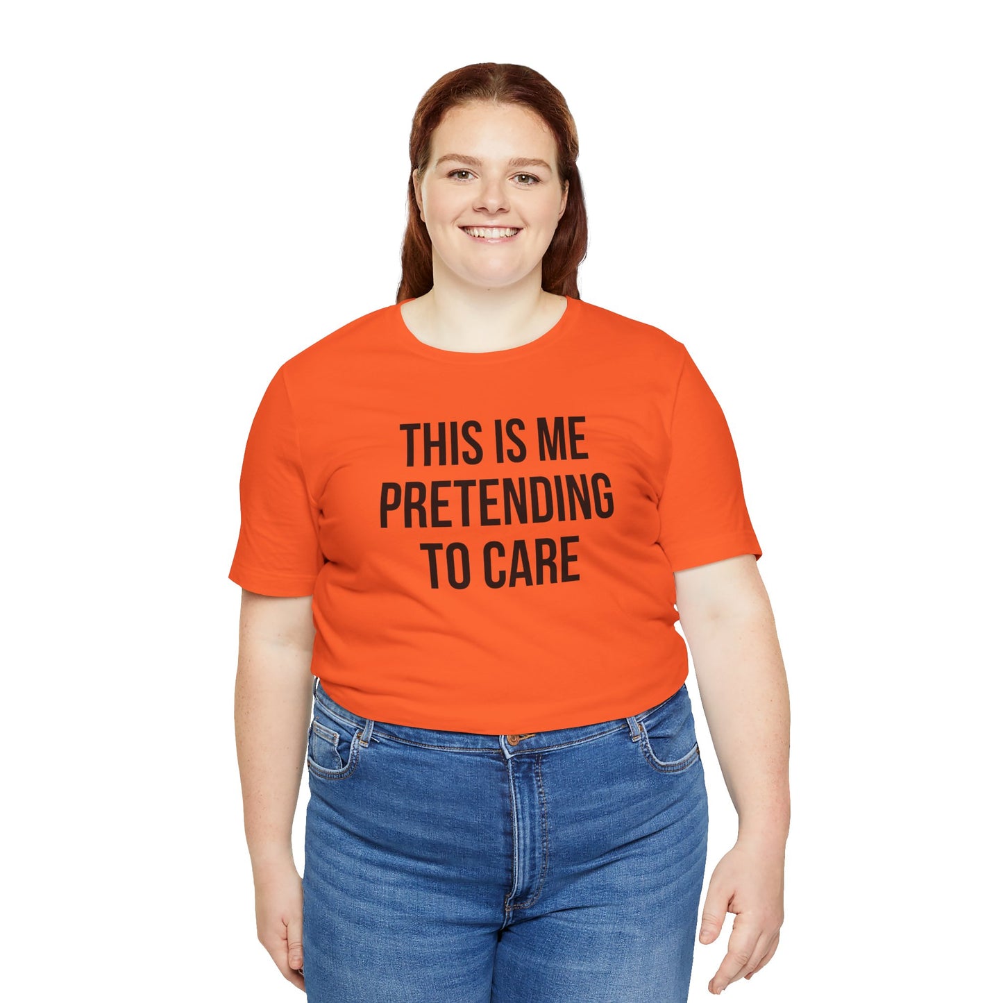 Person wearing an orange t-shirt with text 'This is me pretending to care' on a white background