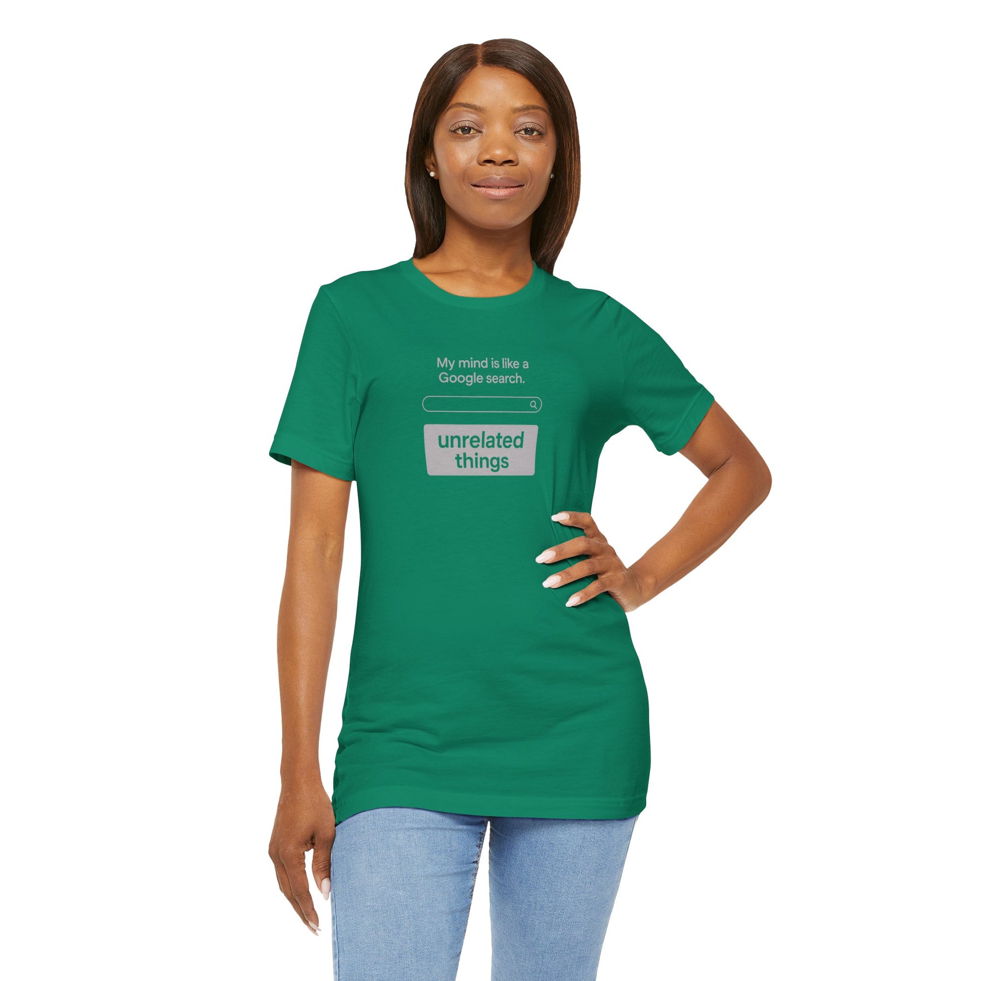 Woman wearing a green t-shirt with text design on a white background. T-shirt has a search bar graphic with text above that says, 'My mind is like a Google search' and text below that says, 'unrelated things.'