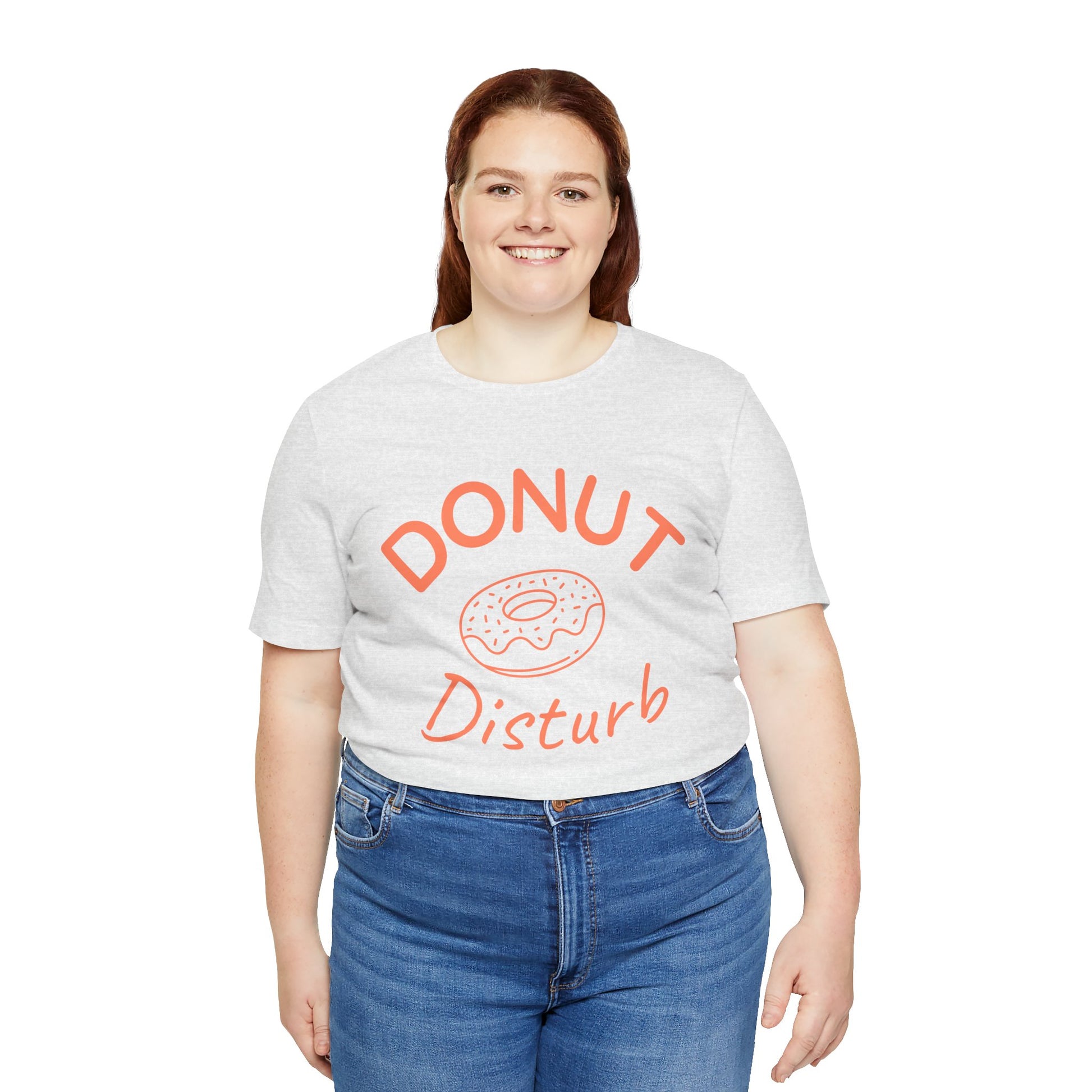 Person wearing a white t-shirt with 'Donut Disturb' text and blue jeans on a white background
