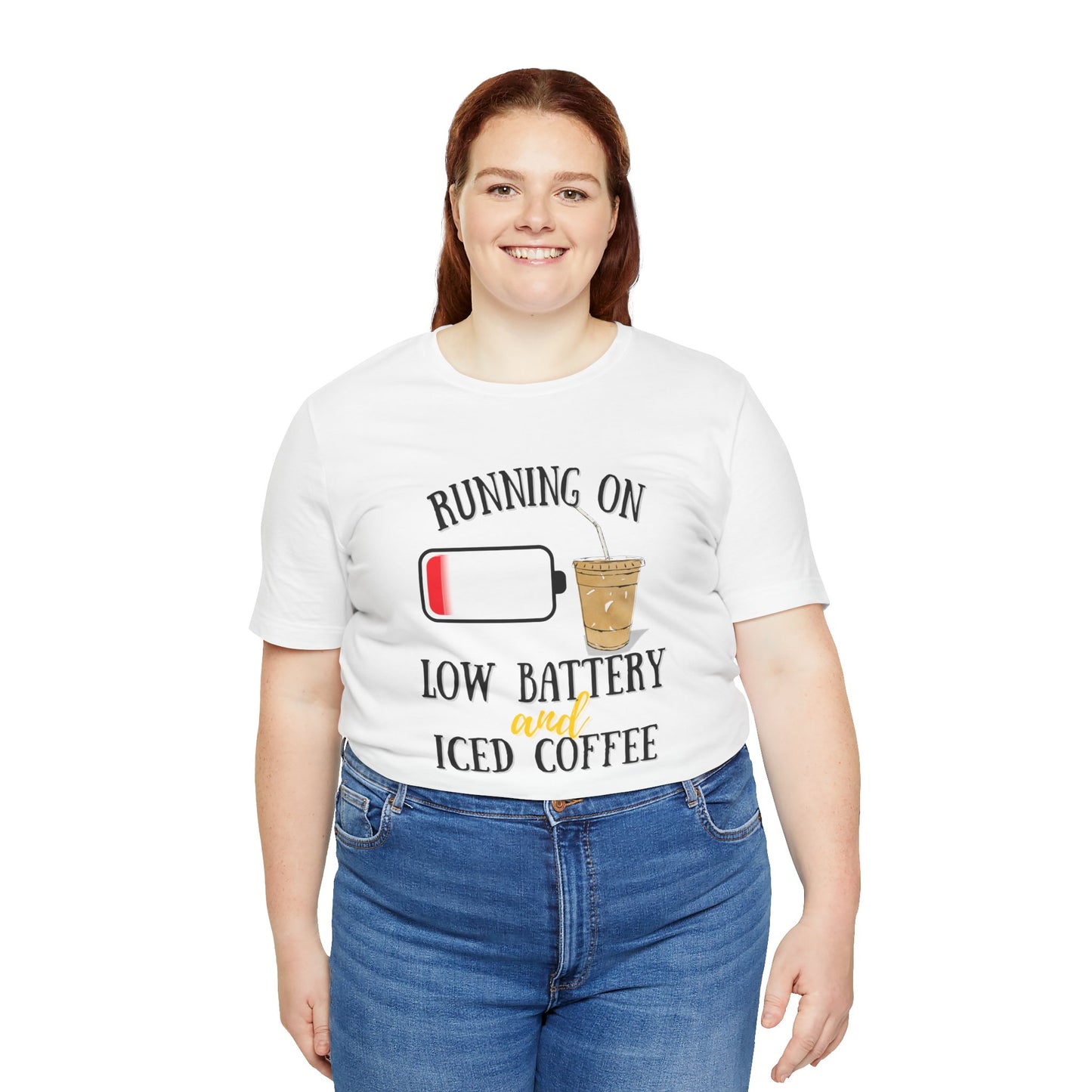 Person wearing a white t-shirt with a humorous graphic and text 'Running on low battery and iced coffee' on a white background