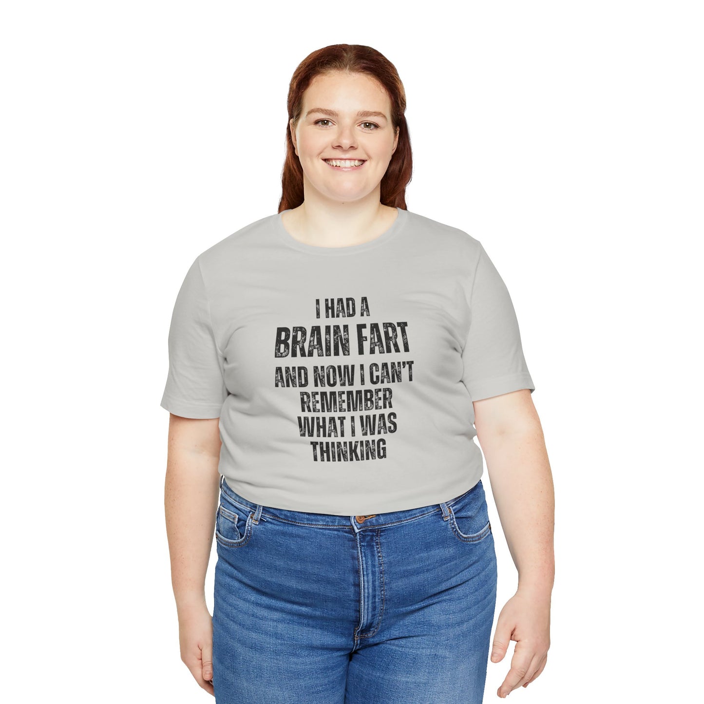 Person wearing a gray t-shirt with humorous text 'I had a brain fart and now I can't remember what I was thinking' design on a white background