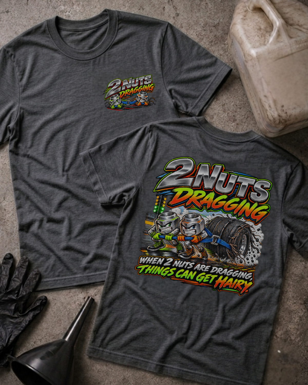 Dark Grey Heather 2 Nuts Dragging T-shirt, front and back views with cartoon nuts pulling a racing tire and the slogan “When 2 nuts are dragging, things can get hairy.”