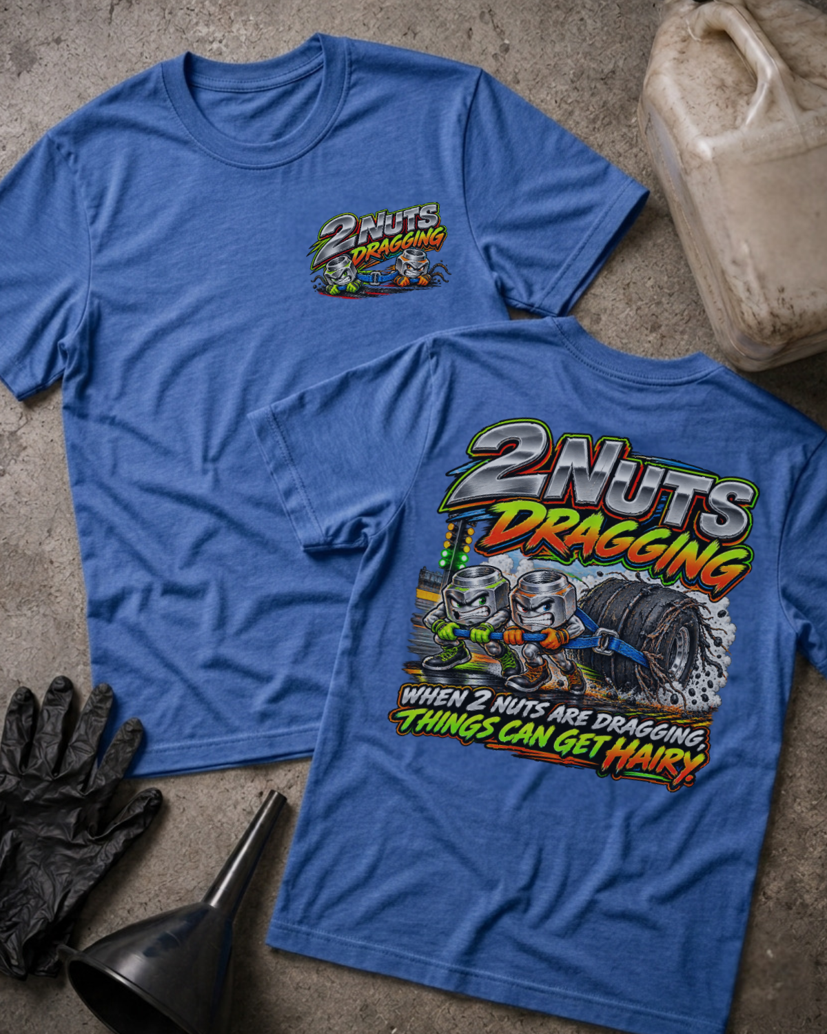 Heather True Royal 2 Nuts Dragging T-shirt, front and back views with cartoon nuts pulling a racing tire and the slogan “When 2 nuts are dragging, things can get hairy.”