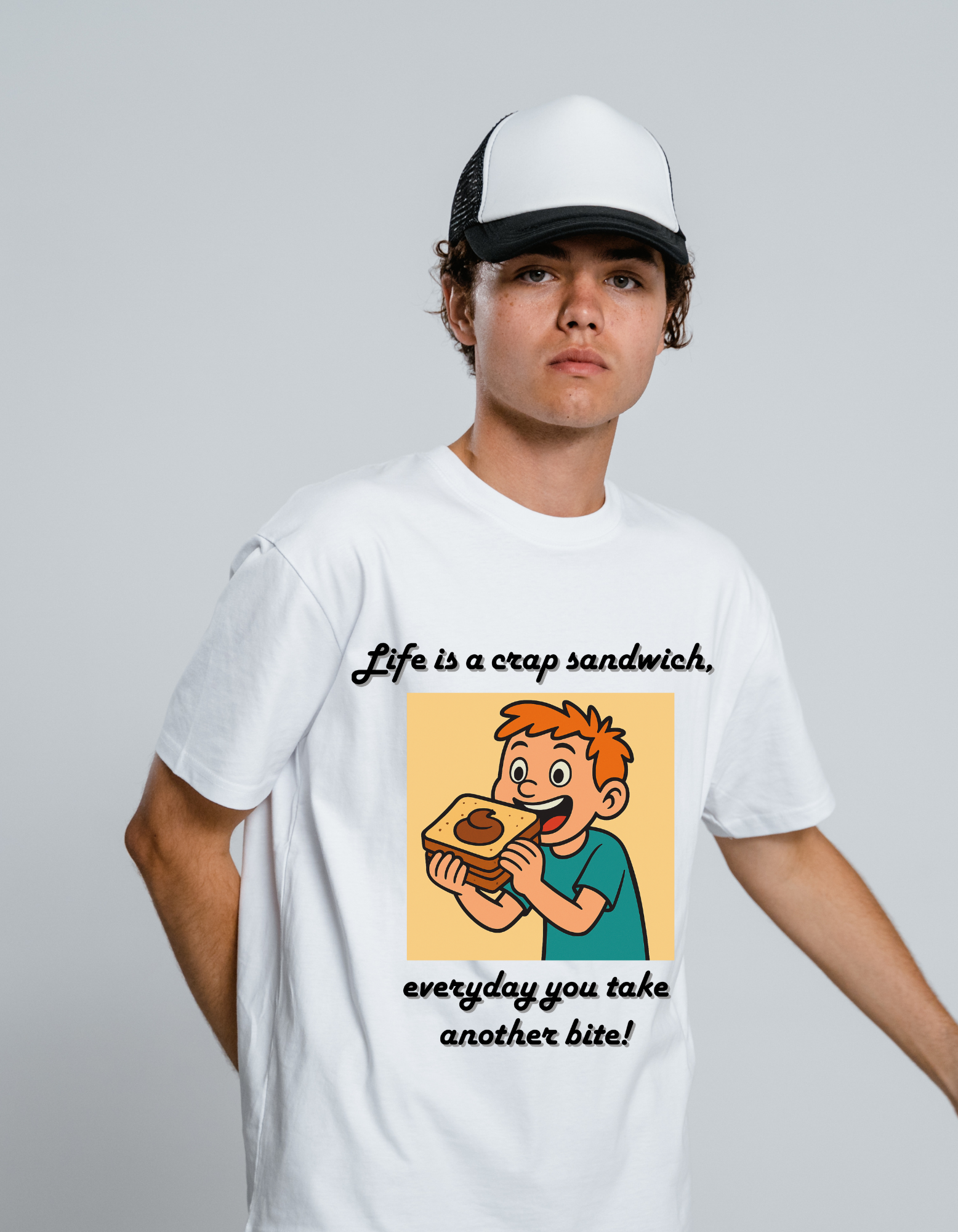 Person wearing a white t-shirt with a graphic of a boy eating a sandwich and text 'Life is a crap sandwich, everyday you take another bite!' on a white background