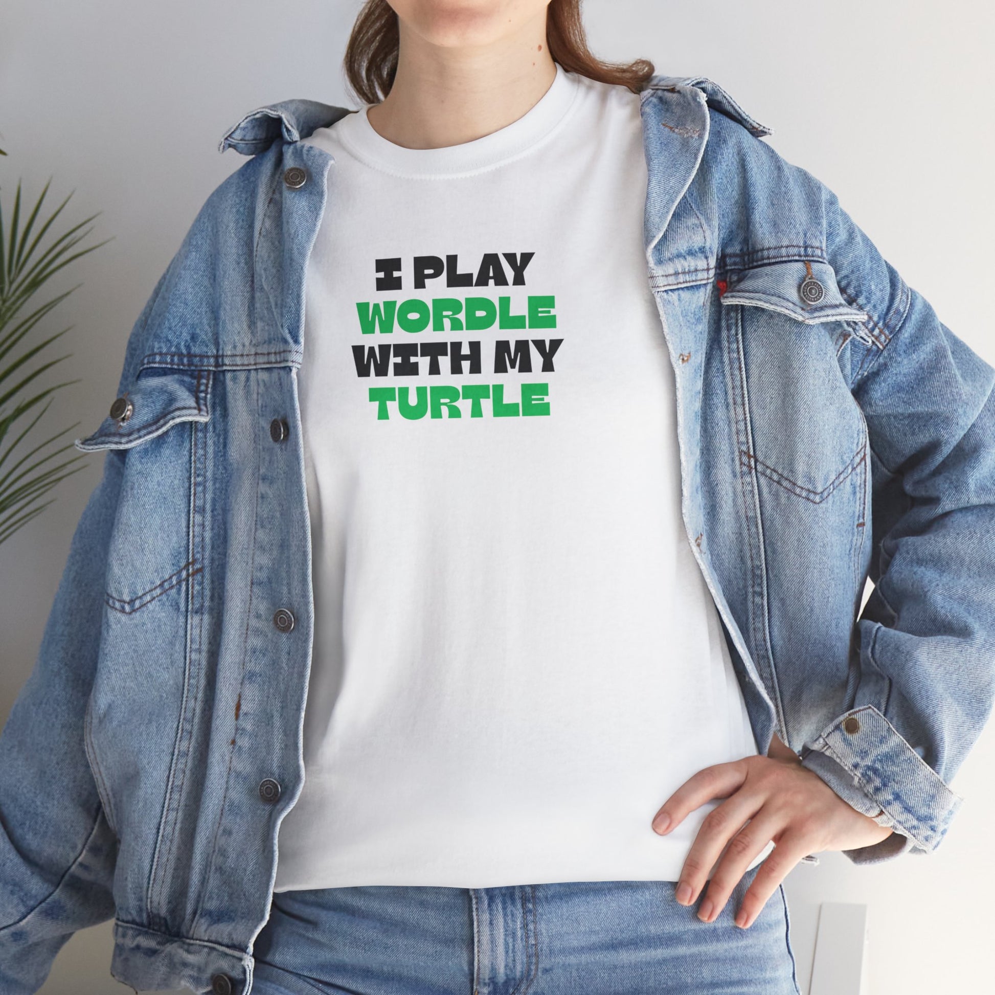 Person wearing a white t-shirt with text 'I play Wordle with my turtle' and a denim jacket.
