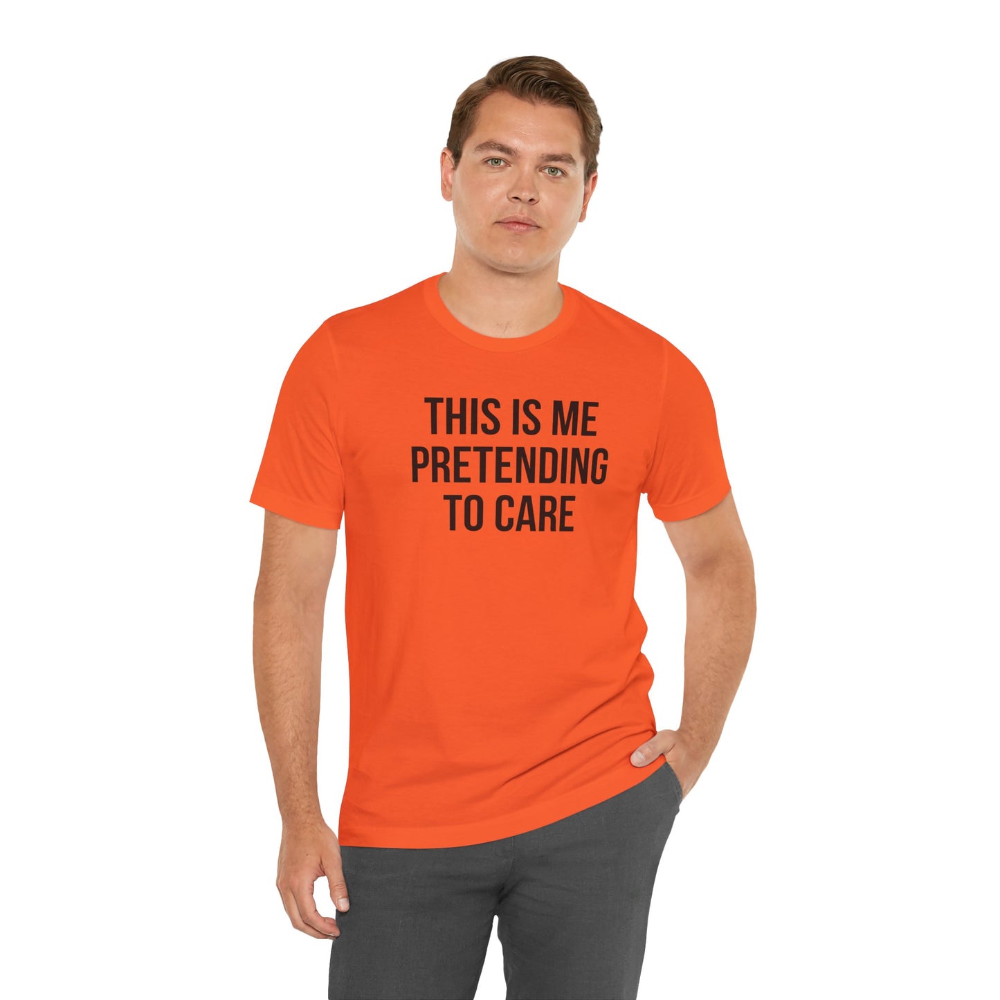 Man wearing an orange t-shirt with text 'This is me pretending to care' on a white background