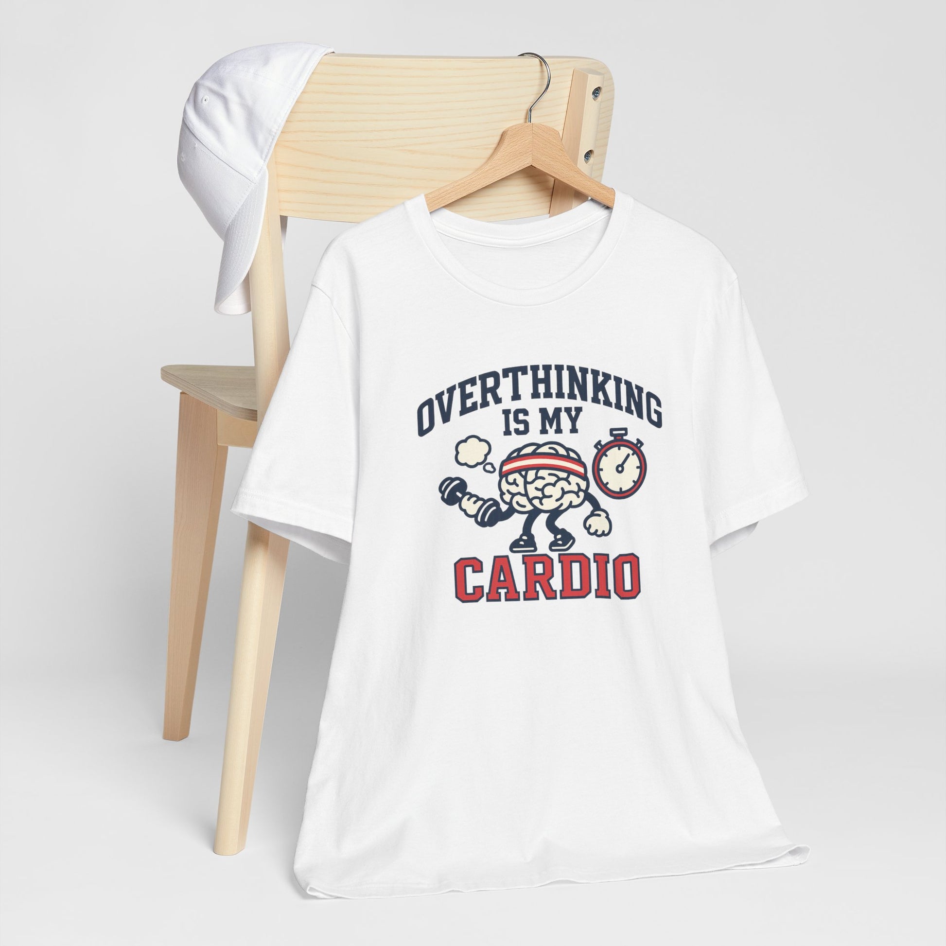 White t-shirt with 'Overthinking is my Cardio' graphic design on a wooden chair.