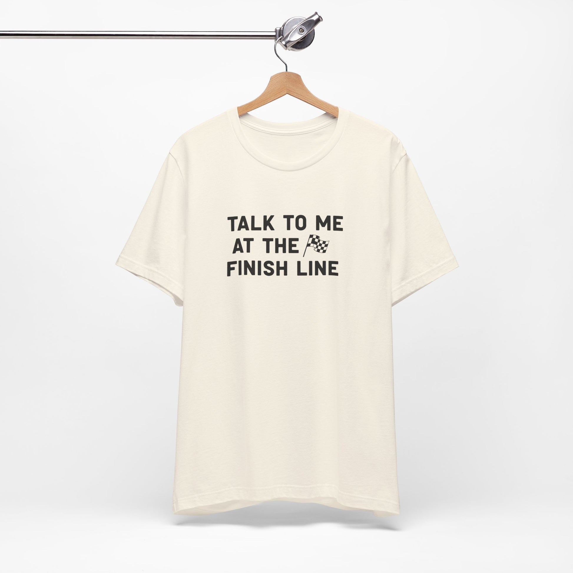 Beige t-shirt with 'Talk to me at the finish line' text on a white background