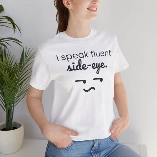Person wearing a white t-shirt with 'I speak fluent side-eye' text and graphic.