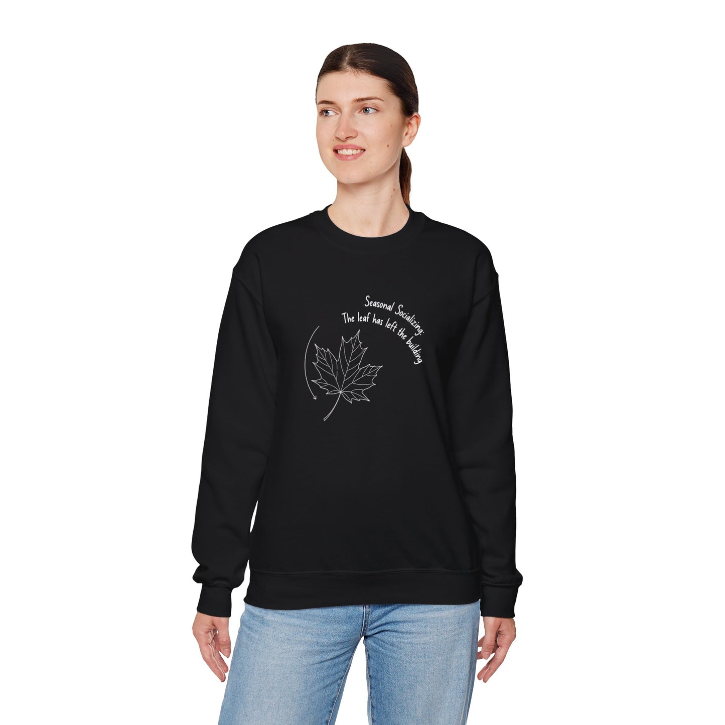 Person wearing a black sweatshirt with a leaf design and text 'Seasonal Socializing, The leaf has left the building' on a white background