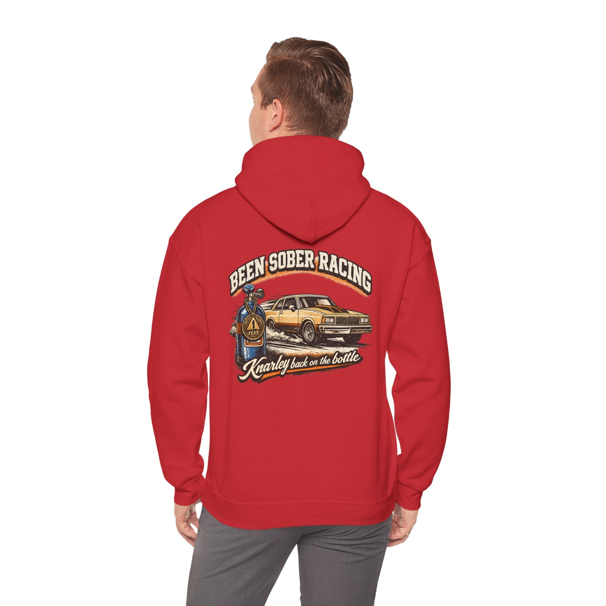 Red hoodie with a graphic design and 'Been Sober Racing Knarley back on the bottle' text on the back worn by a person, on a white background