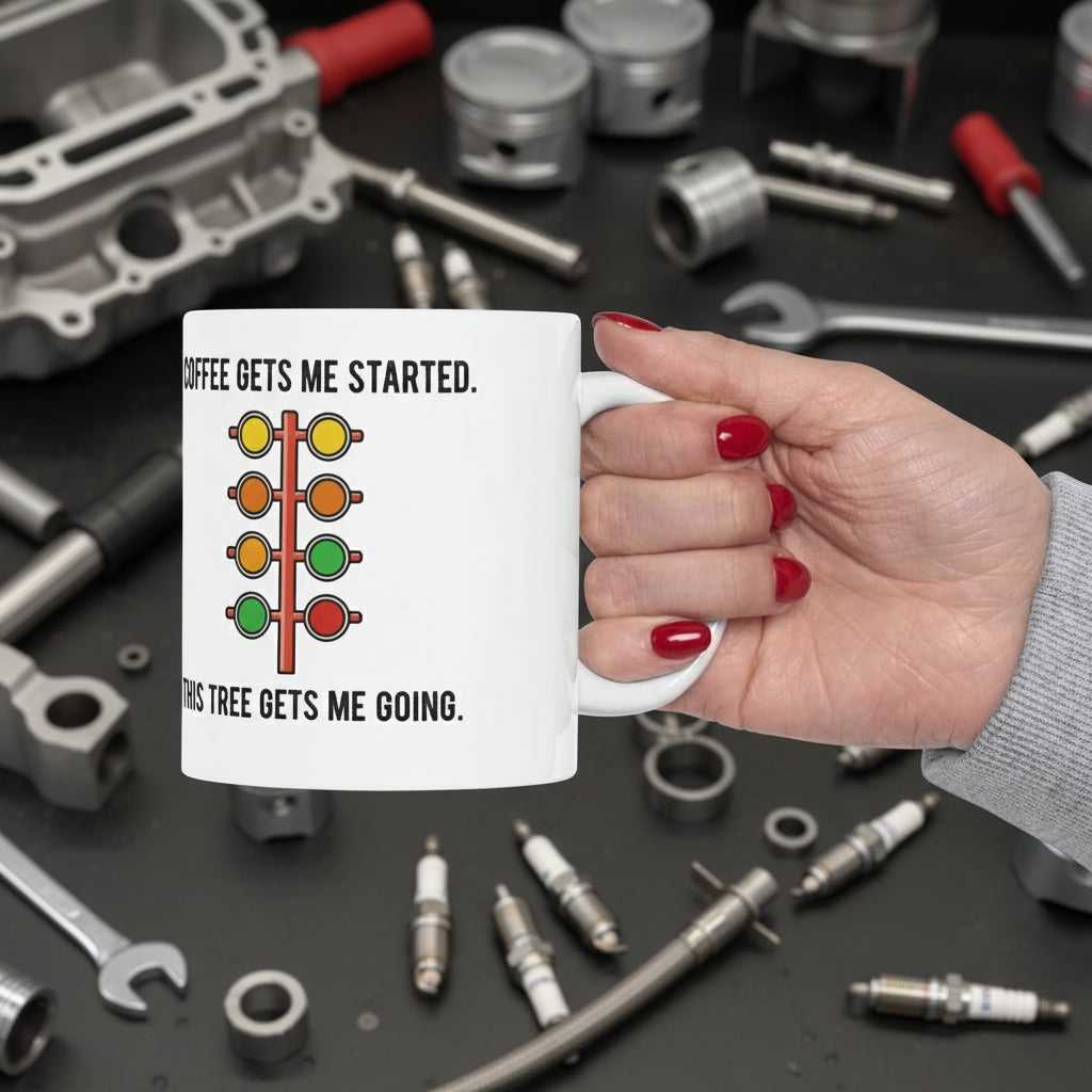 Hand holding a mug with a traffic light design and 'Coffee gets me started. This tree gets me going' text on a white background