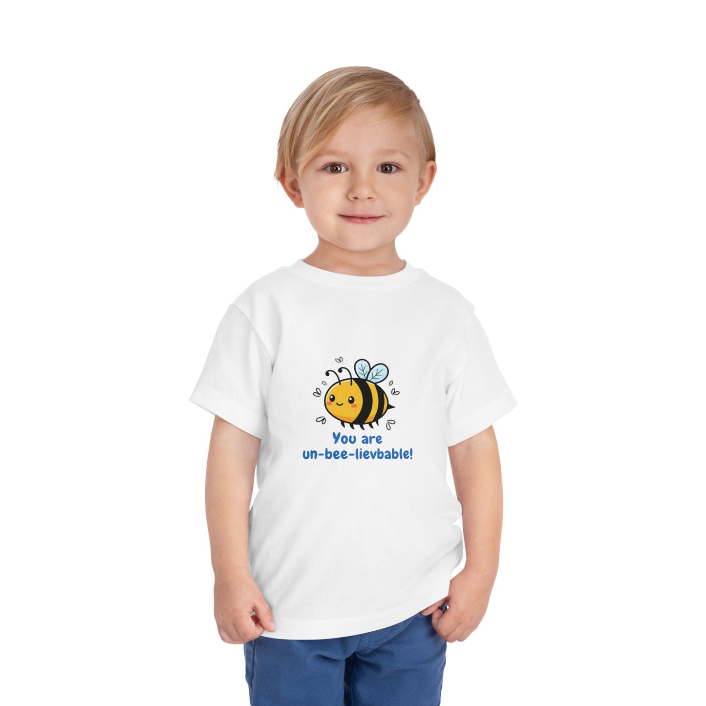 Child wearing a white 'You Are Un-Bee-Lievable' toddler t-shirt with cute bee graphic – Bella+Canvas 3001T on a white background