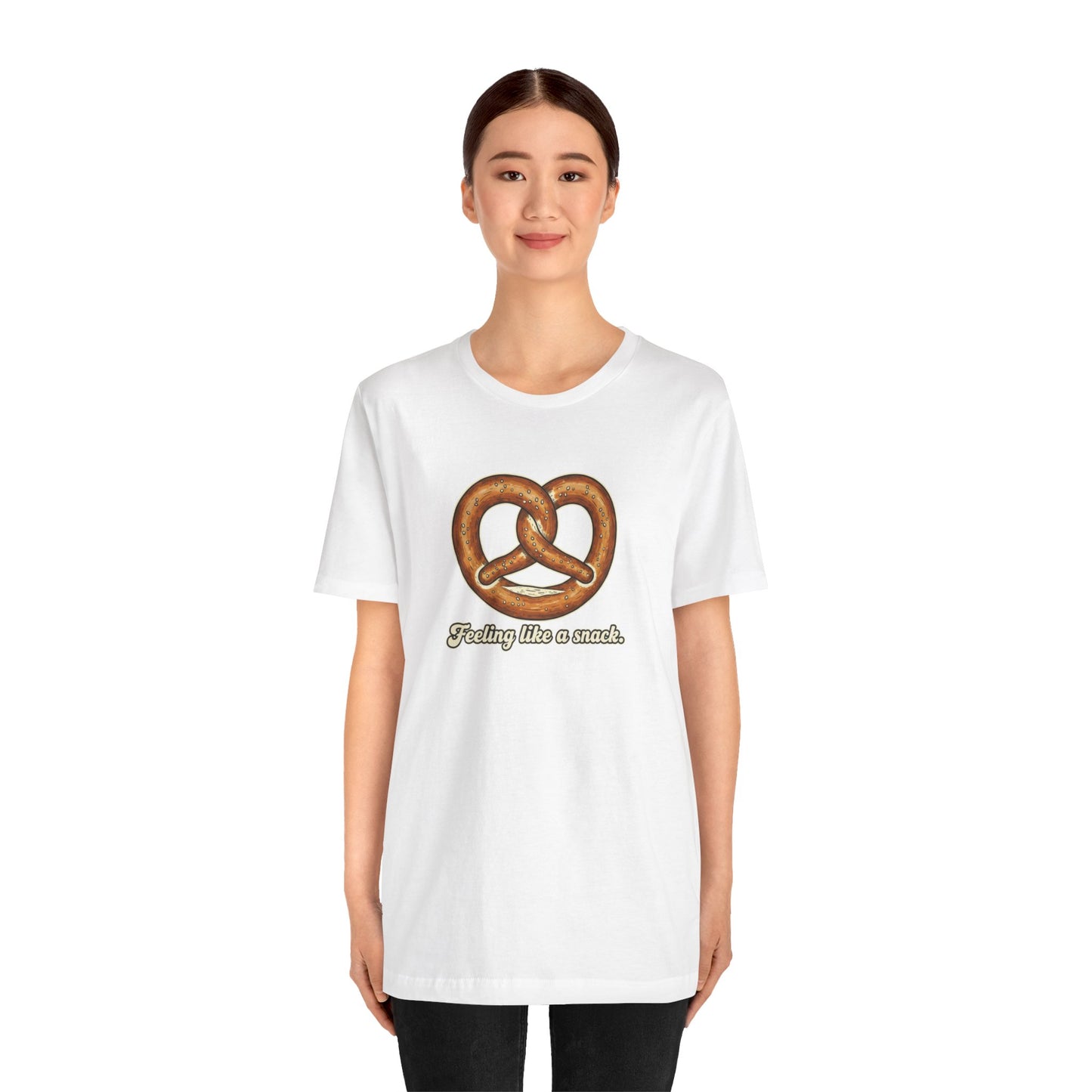 Person wearing a white t-shirt with a pretzel graphic and text 'Feeling like a snack' on a white background