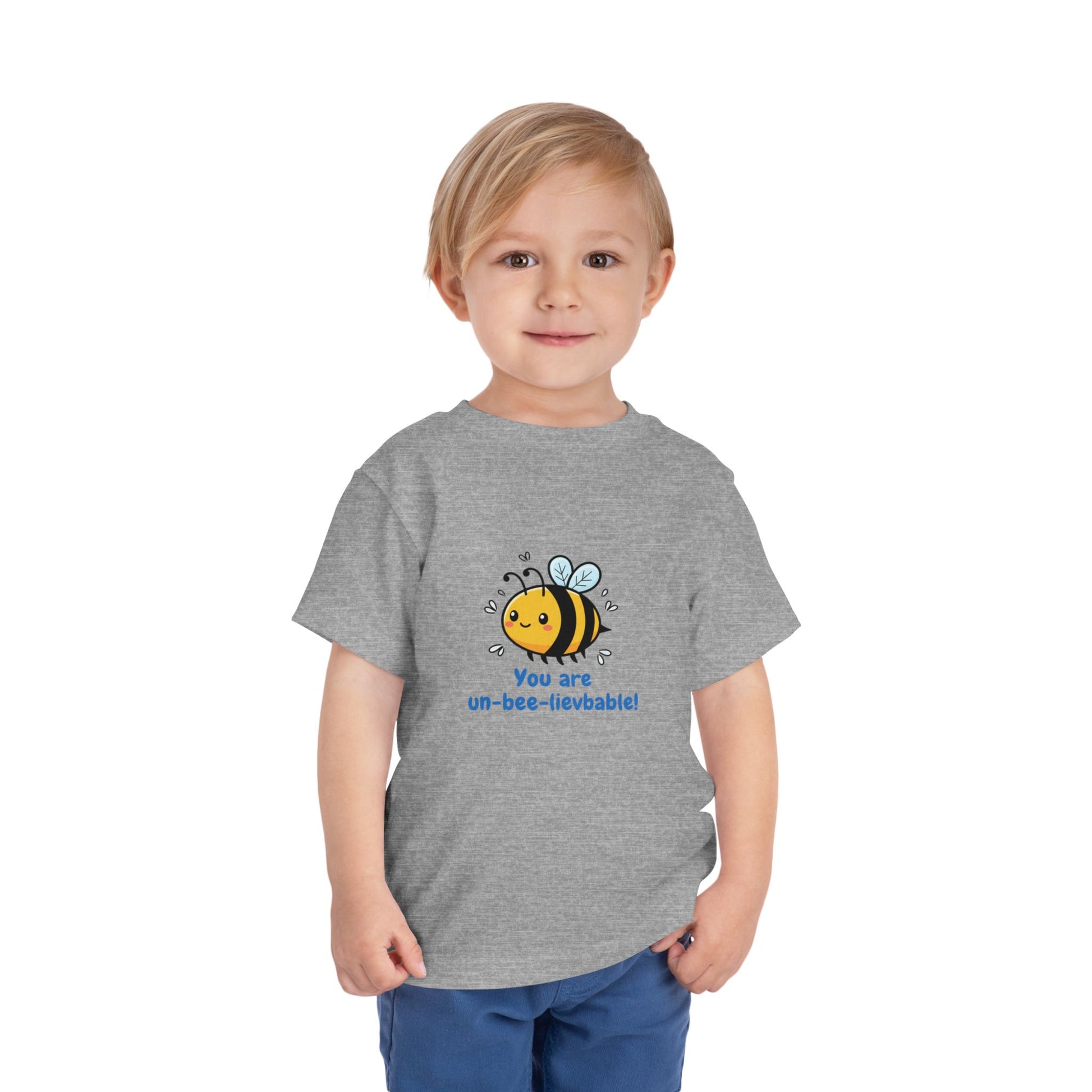 Child wearing a athletic heather 'You Are Un-Bee-Lievable' toddler t-shirt with cute bee graphic – Bella+Canvas 3001T on a white background