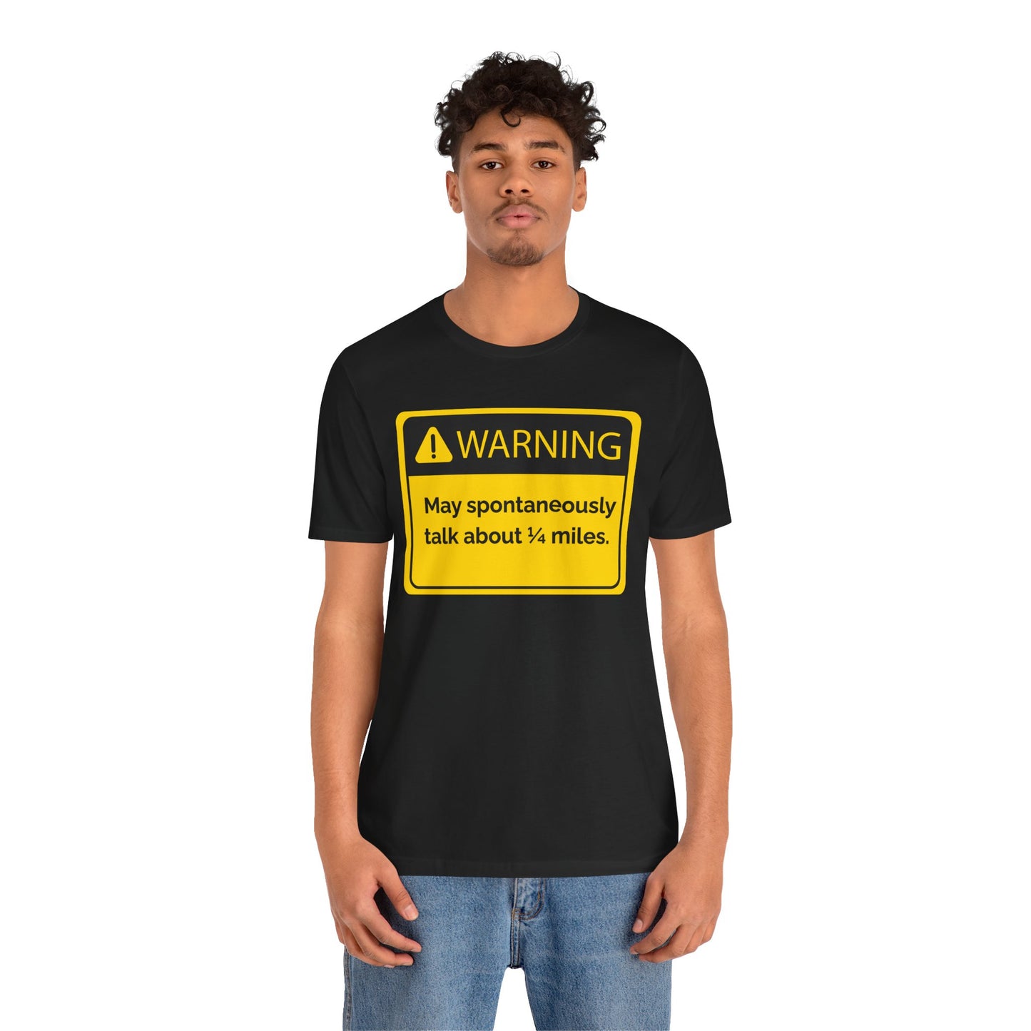 Person wearing a black t-shirt with a yellow warning sign 'WARNING May spontaneously talk about 1/4 miles' graphic.