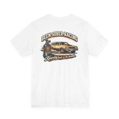 White t-shirt with a graphic design of a car and 'Been Sober Racing Knarley back on the bottle' text on a white background