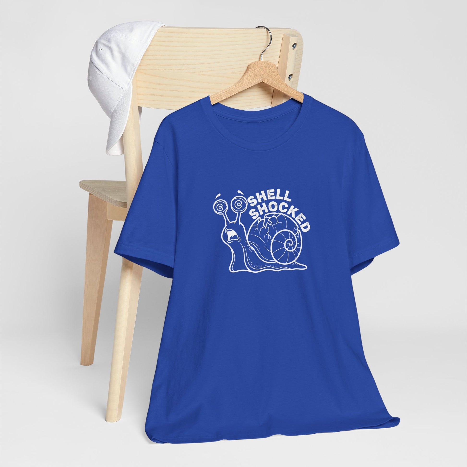 Blue t-shirt with a snail graphic and 'Shell Shocked' text on a white background