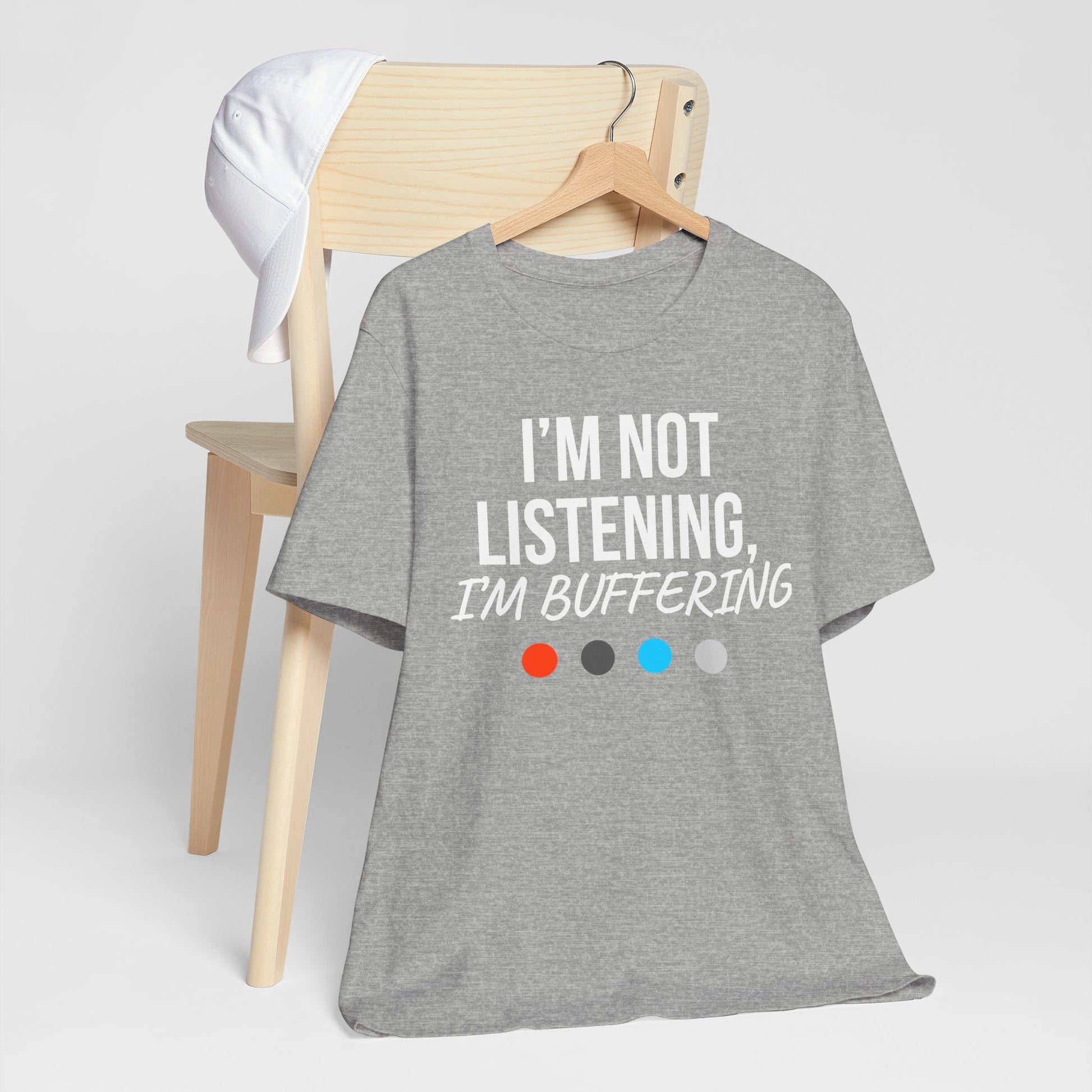 Gray t-shirt with 'I'm not listening, I'm buffering' text on a hanger against a white background