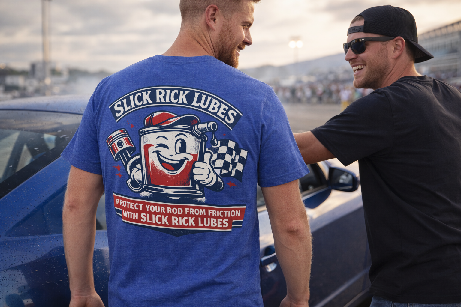Two men standing next to a car at a drag race with one wearing a blue t-shirt featuring 'Slick Rick Lubes' branding.
