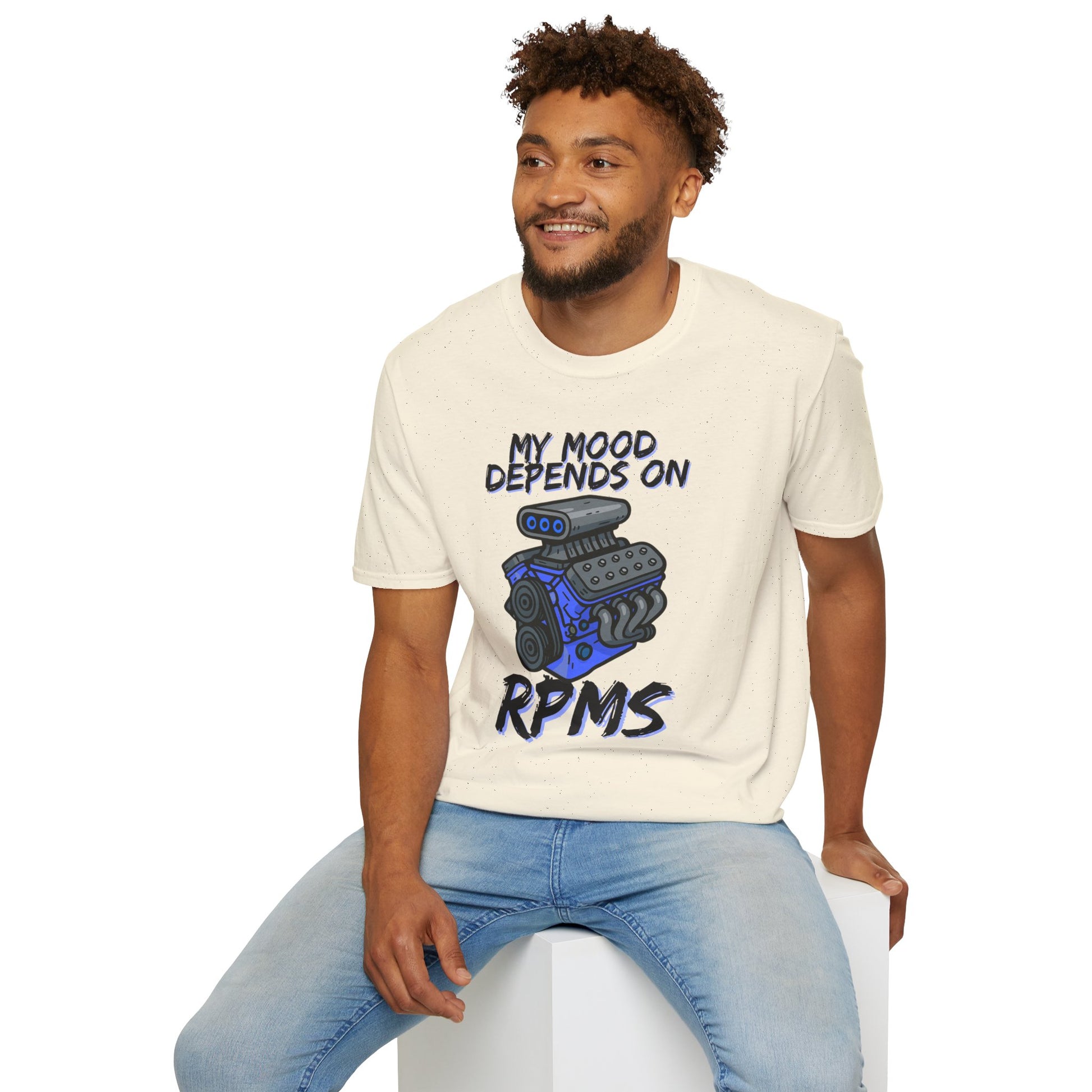 Man wearing a t-shirt with a graphic and text, sitting on a white stool against a white background
