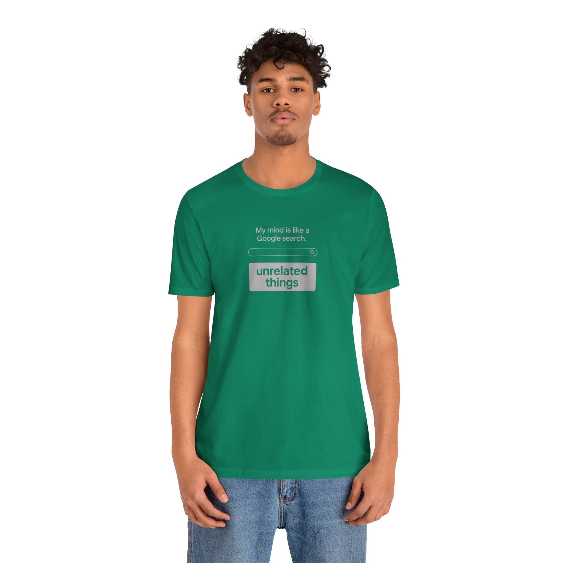 Person wearing a green t-shirt with text on a white background. T-shirt has a search bar graphic with text above that says, 'My mind is like a Google search' and text below that says, 'unrelated things.'