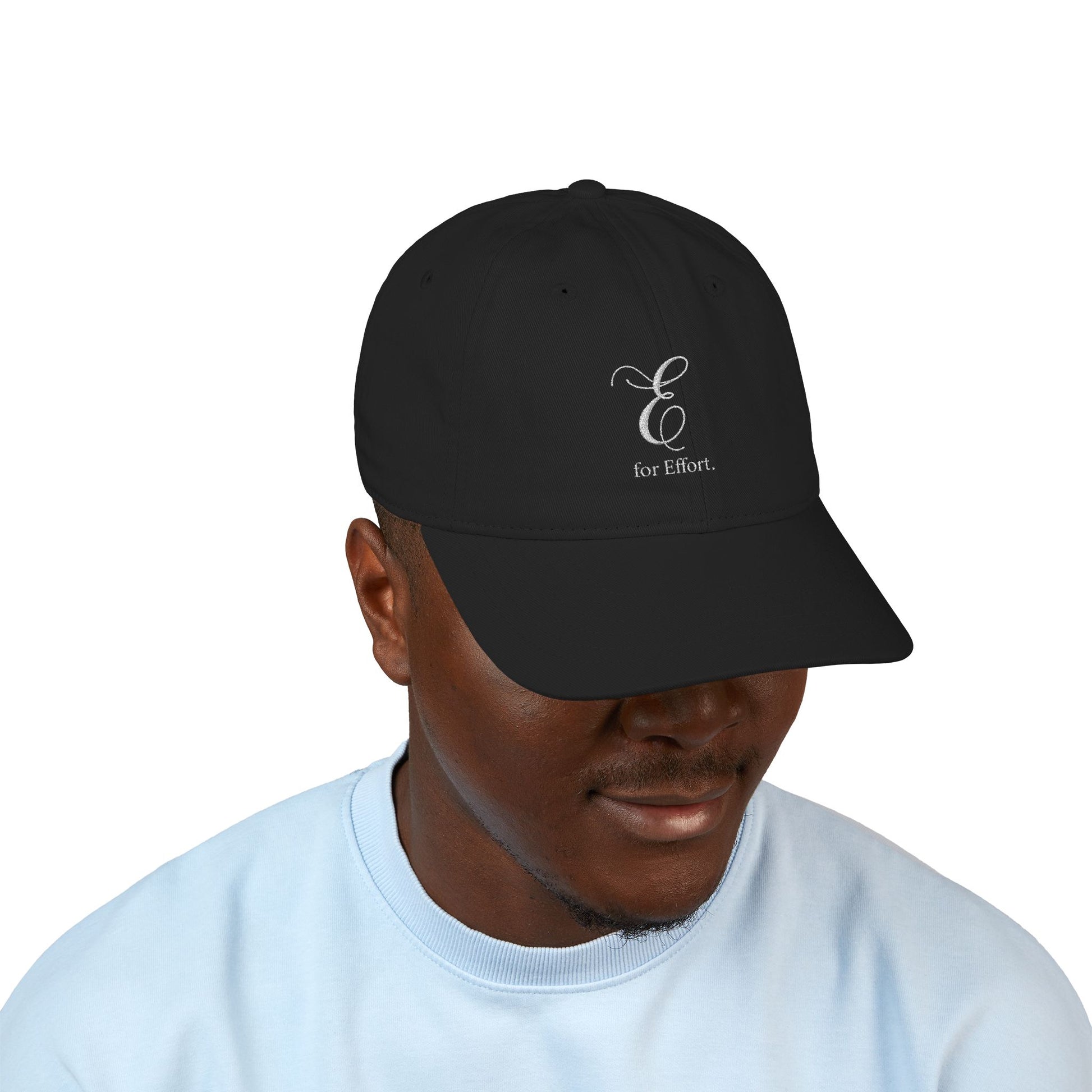 Person wearing a black cap with text 'E for Effort' on a white background