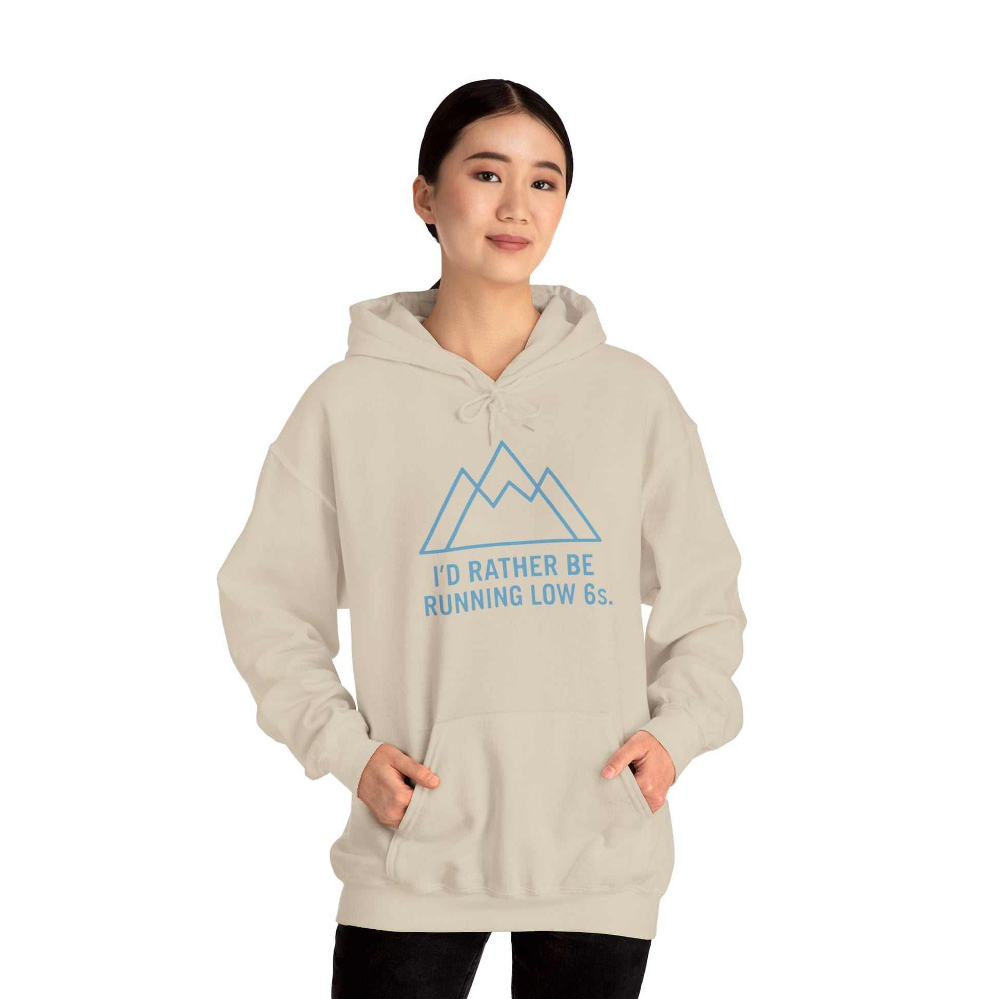Person wearing a beige hoodie with blue text 'I'd rather be running low 6s' and mountain graphic on a white background