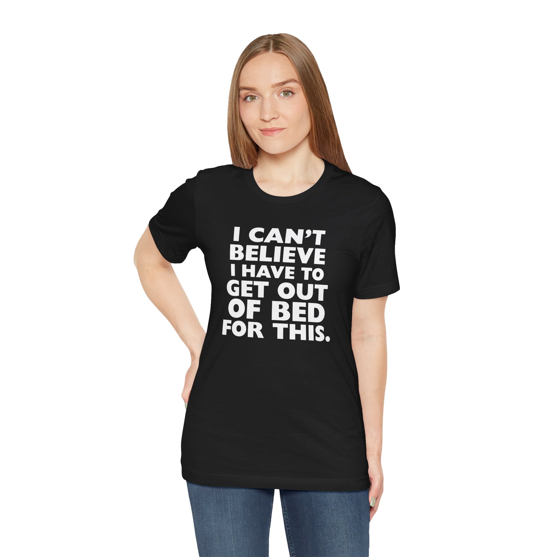 Person wearing a black t-shirt with white text 'I can't believe I have to get out of bed for this' on a white background