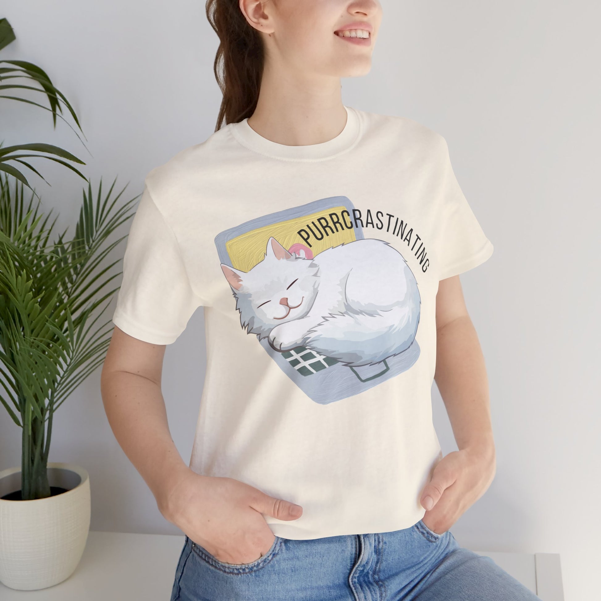 Person wearing a white t-shirt with a cat graphic and text 'Purrcrastinating', standing against a plain background.