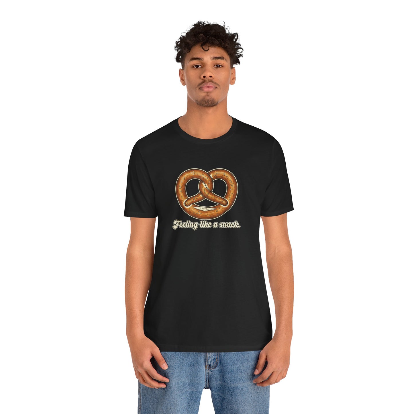 Person wearing a black t-shirt with a pretzel graphic and text that says "Feeling like a snack" on a white background
