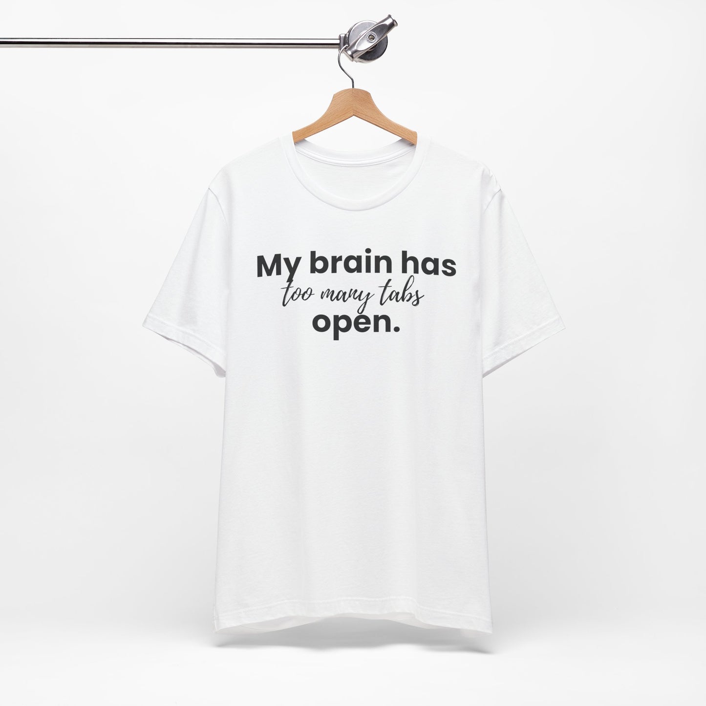 White t-shirt with text 'My brain has too many tabs open' on a hanger against a white background
