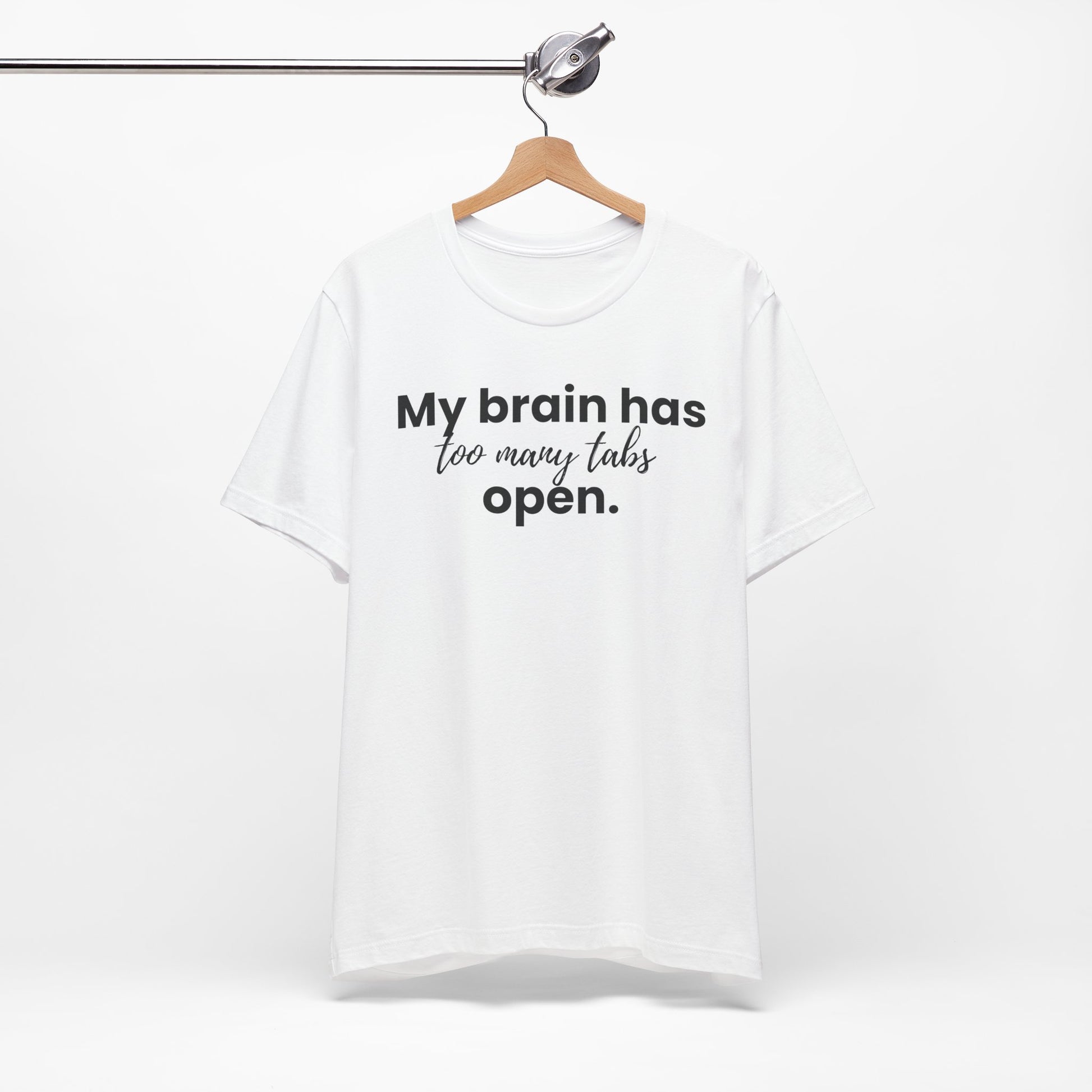 White t-shirt with text 'My brain has too many tabs open' on a hanger against a white background