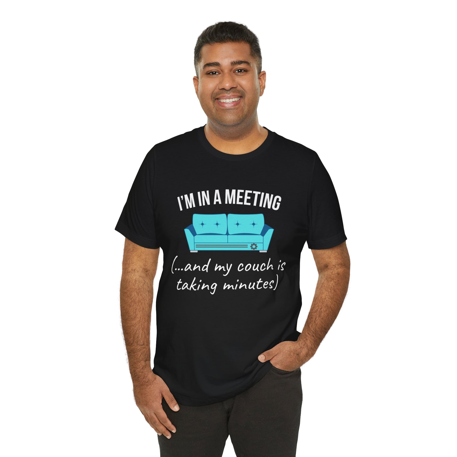 Man wearing a black t-shirt with humorous text 'I'm in a meeting (...and my couch is taking minutes)'and graphic design on a white background