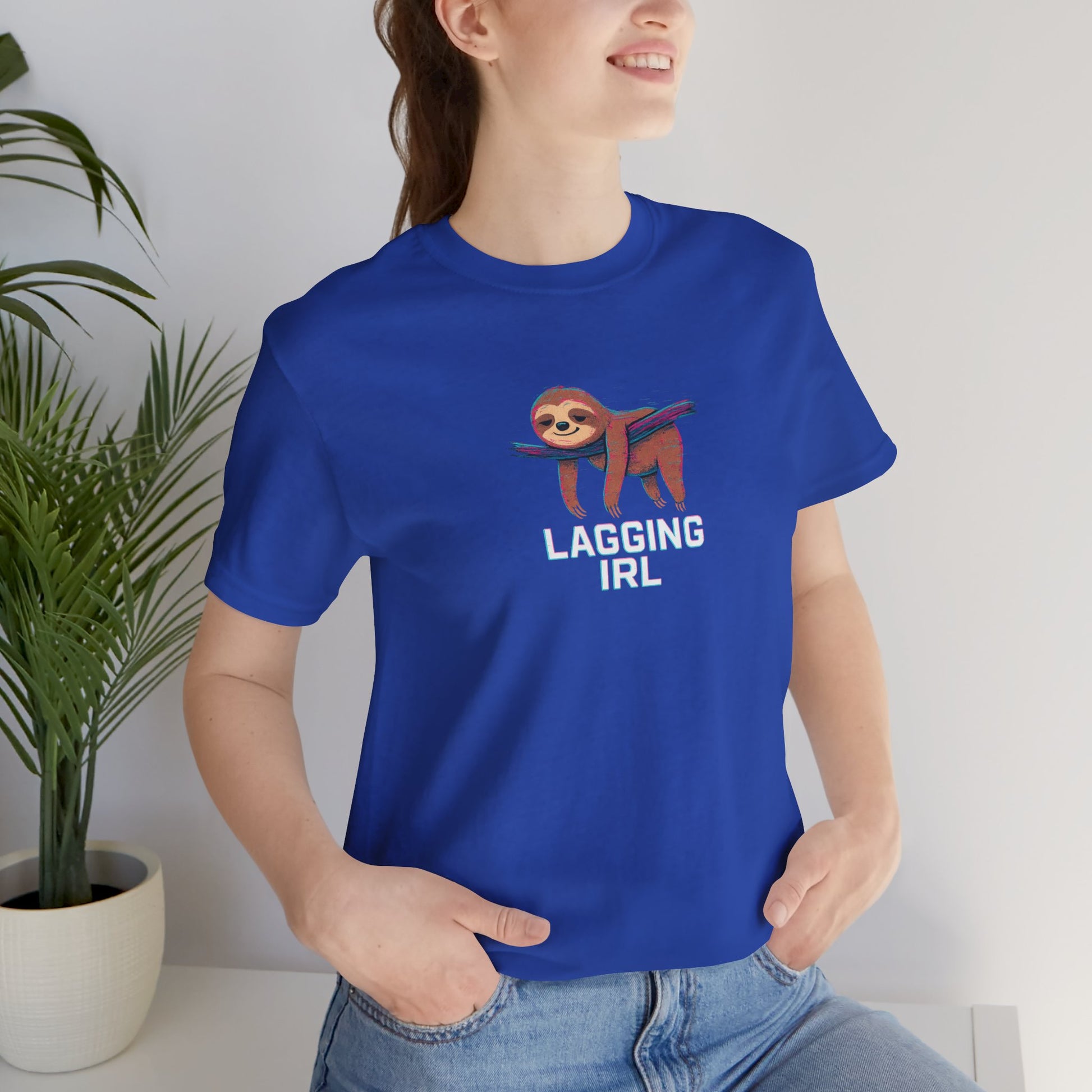 Person wearing a blue t-shirt with a sloth graphic and text 'Lagging IRL', standing indoors.