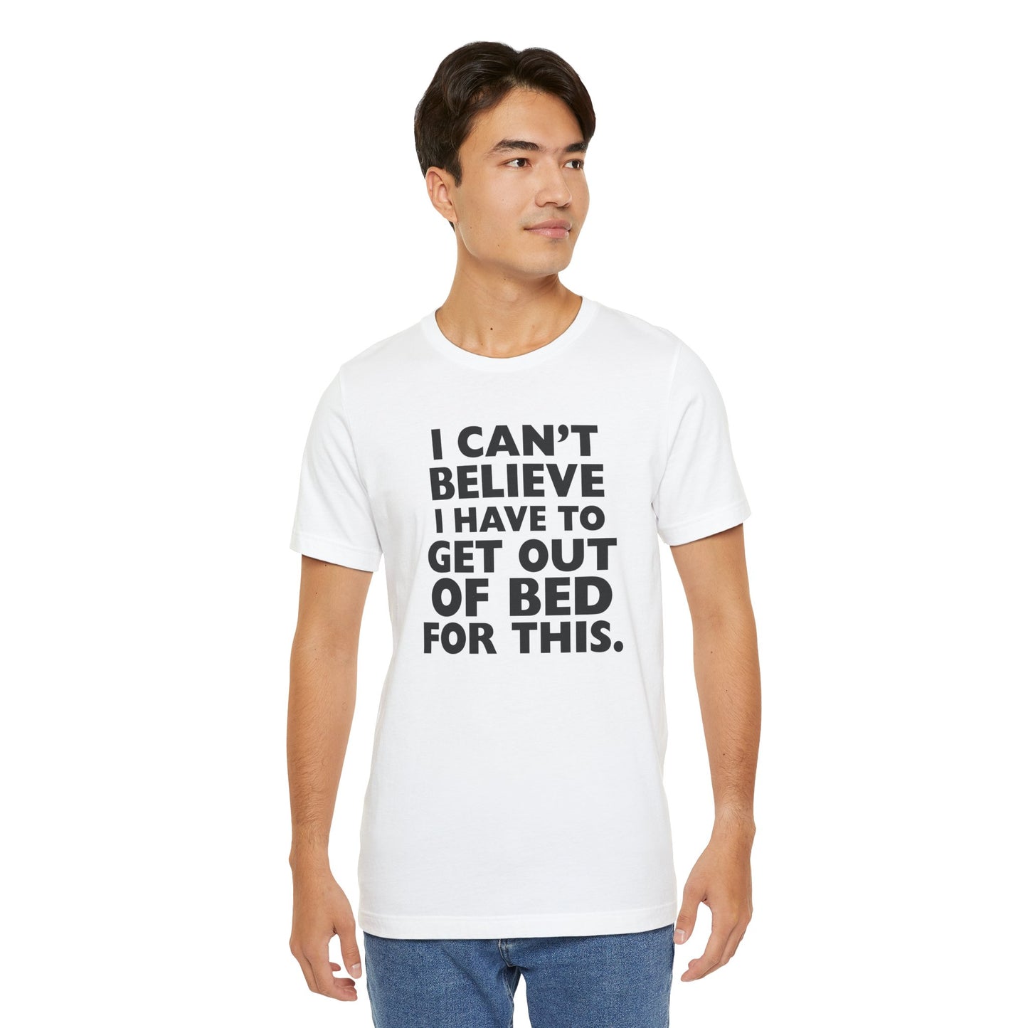 Man wearing a white t-shirt with black text 'I can't believe I have to get out of bed for this' on a white background