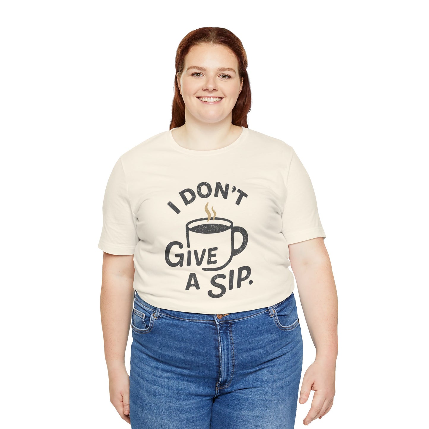 Person wearing a cream t-shirt with a coffee-themed graphic and 'I don't give a sip' text on a white background