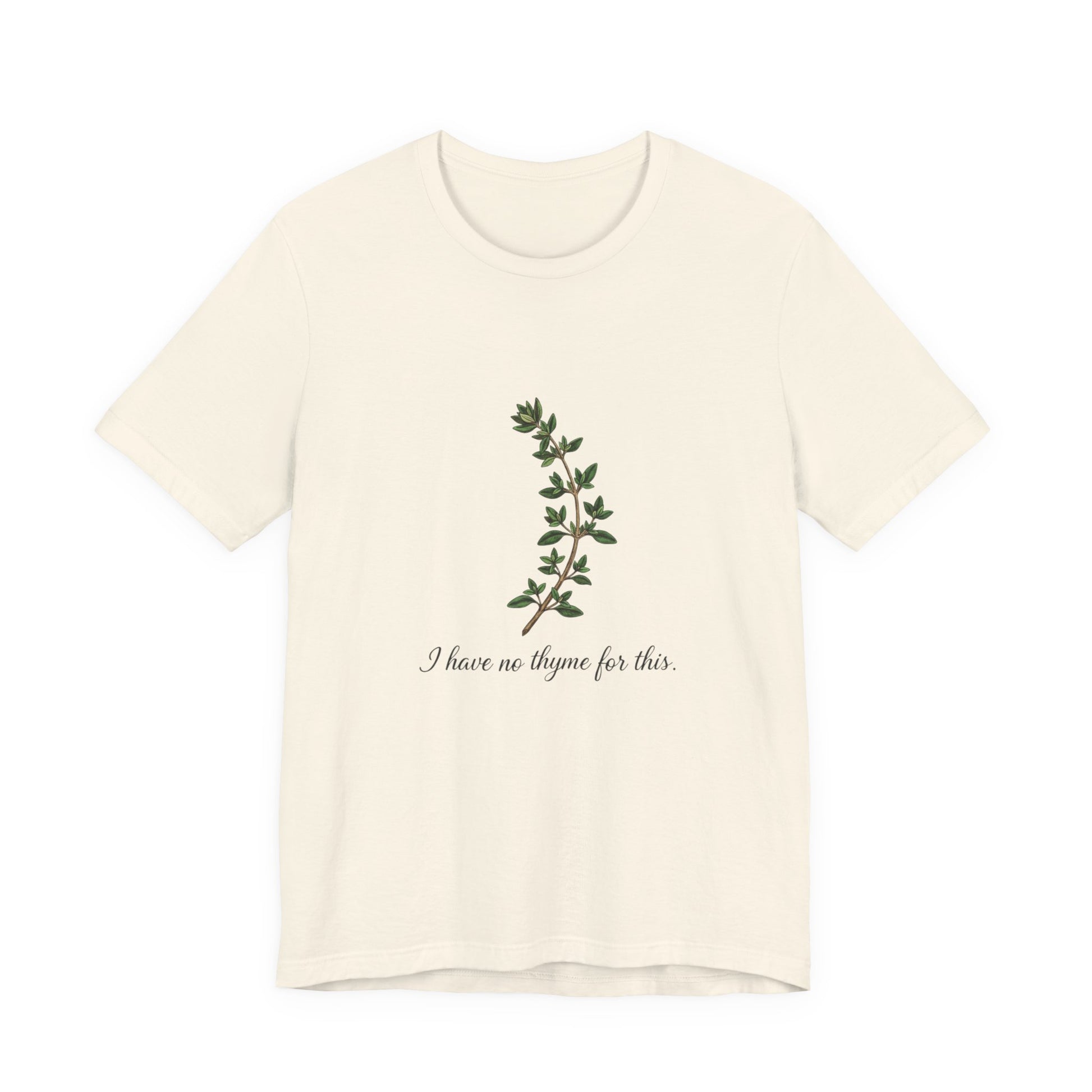 Beige t-shirt with green leaf design and text 'I have no thyme for this' on a white background