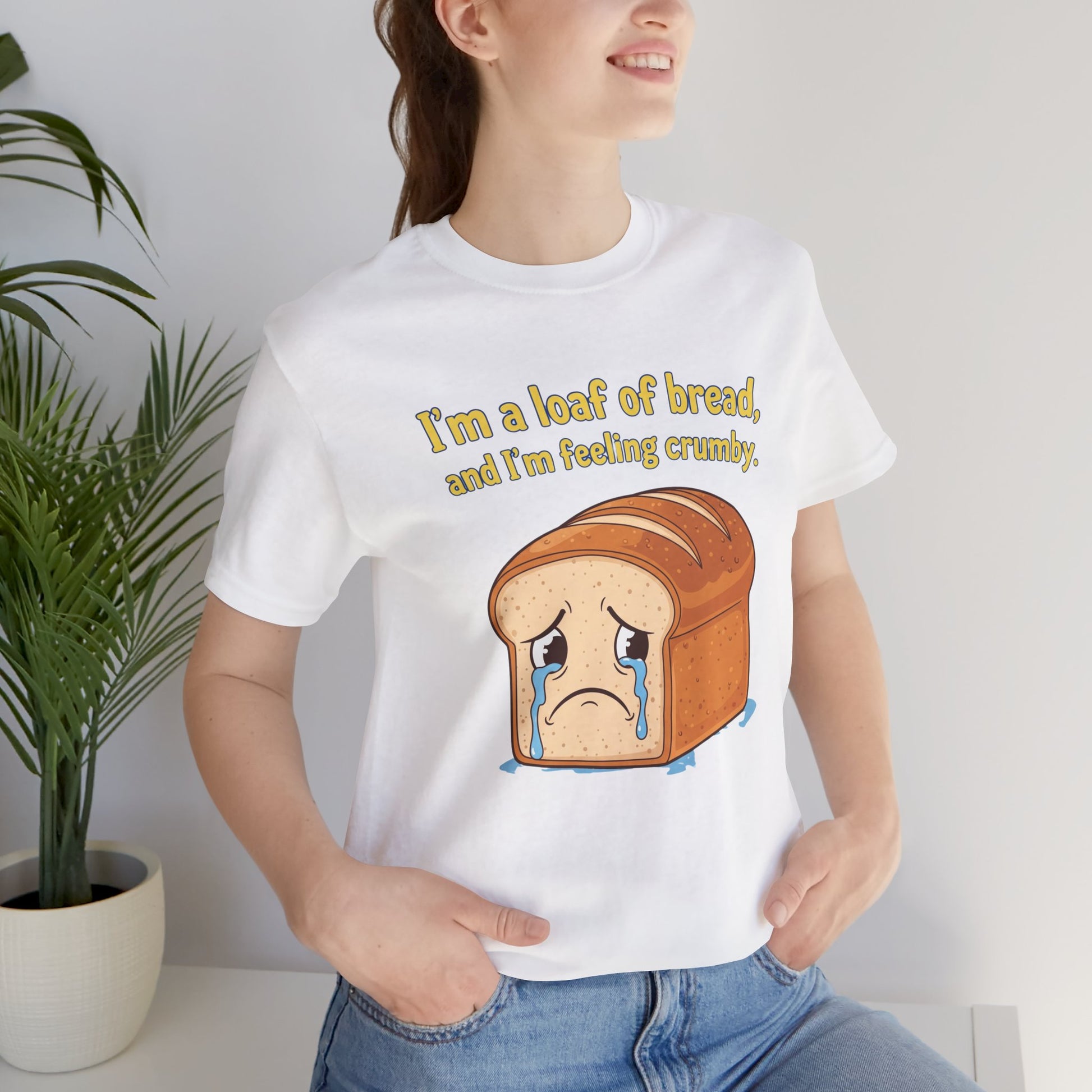 Unisex Bella+Canvas 3001 t-shirt featuring a sad cartoon loaf of bread with tears and the pun text ‘I’m a loaf of bread, and I’m feeling crumby.’ Available in white, black, athletic heather, natural, and true royal.
