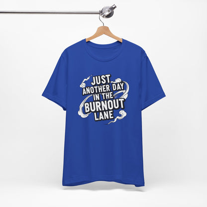 Blue t-shirt with text 'Just another day in the burnout lane' on a hanger against a white background