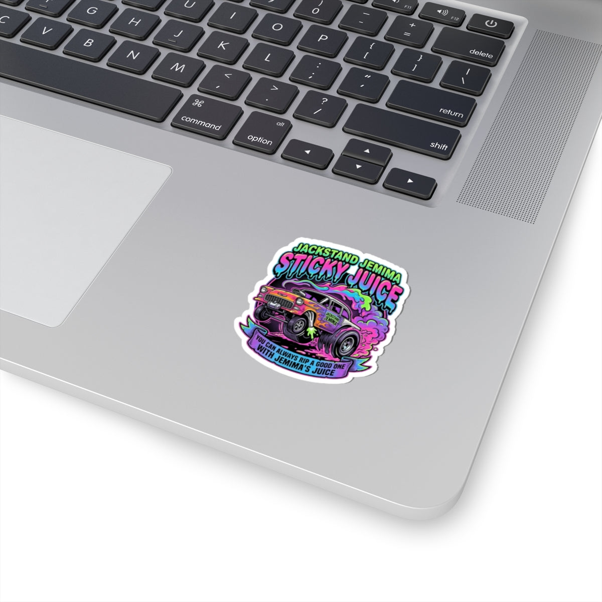 Laptop with a colorful 'Sticky Juice' sticker on the palm rest area
