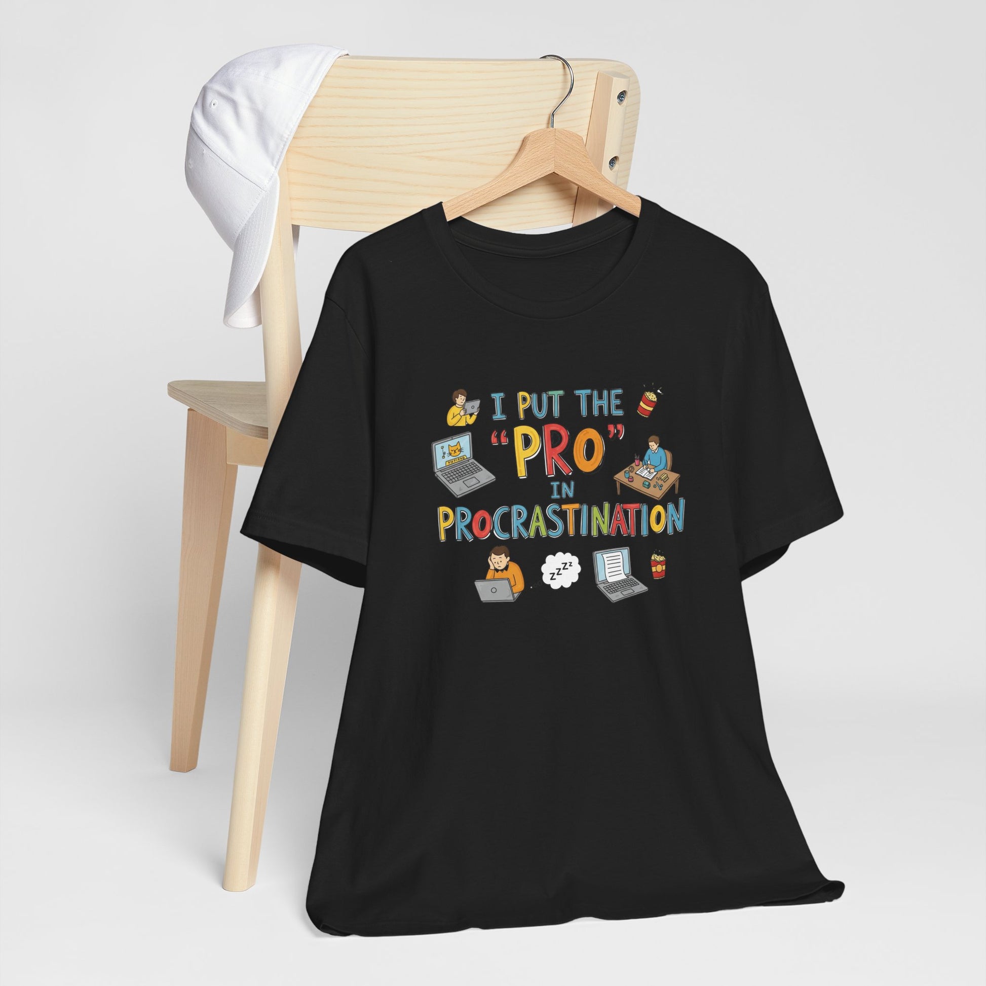 Black t-shirt with humorous design on a wooden chair against a white background