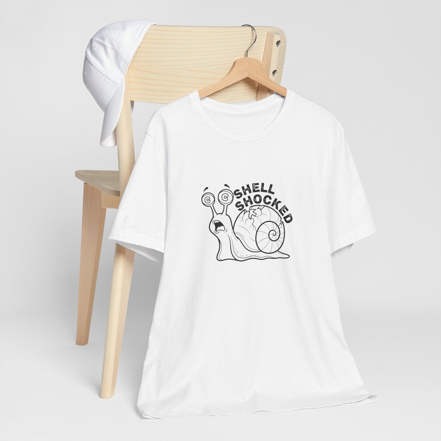 White t-shirt with a snail graphic and 'Shell Shocked' text on a white background