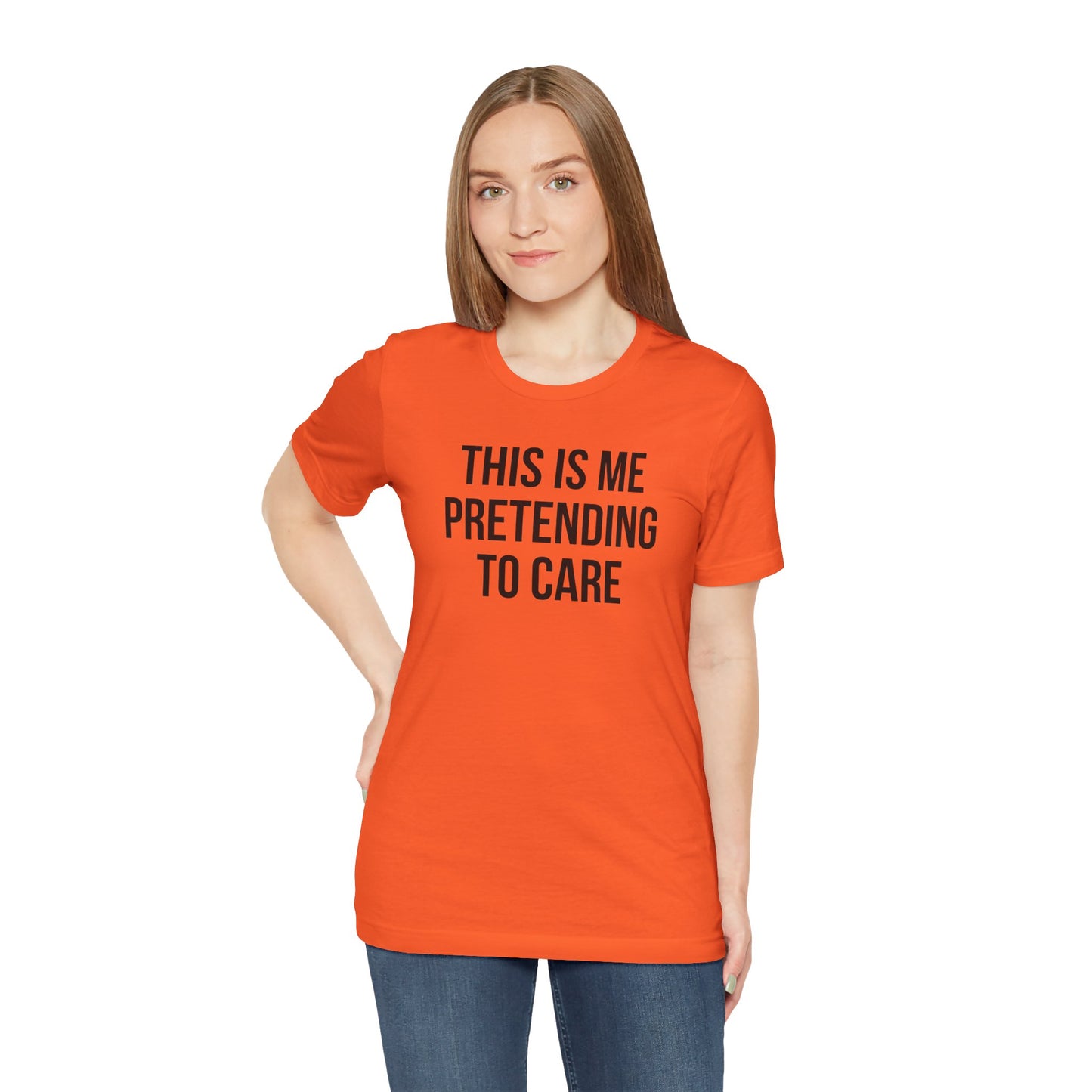 Person wearing an orange t-shirt with text 'This is me pretending to care' on a white background